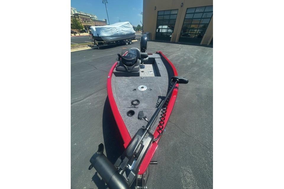 2026 Tracker Super Guide V-16 SC boat, red exterior, parked outdoors on pavement.