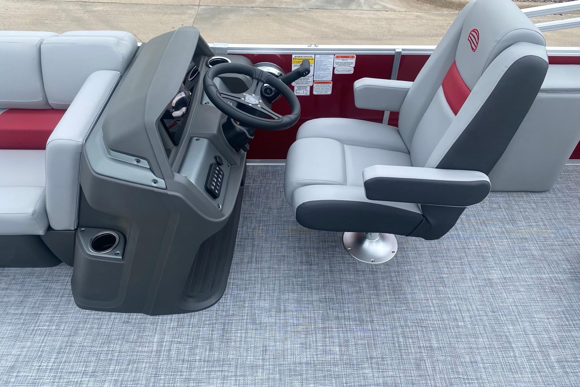 2026 Sun Tracker Party Barge 22 RF DLX interior with captain's chair and helm.