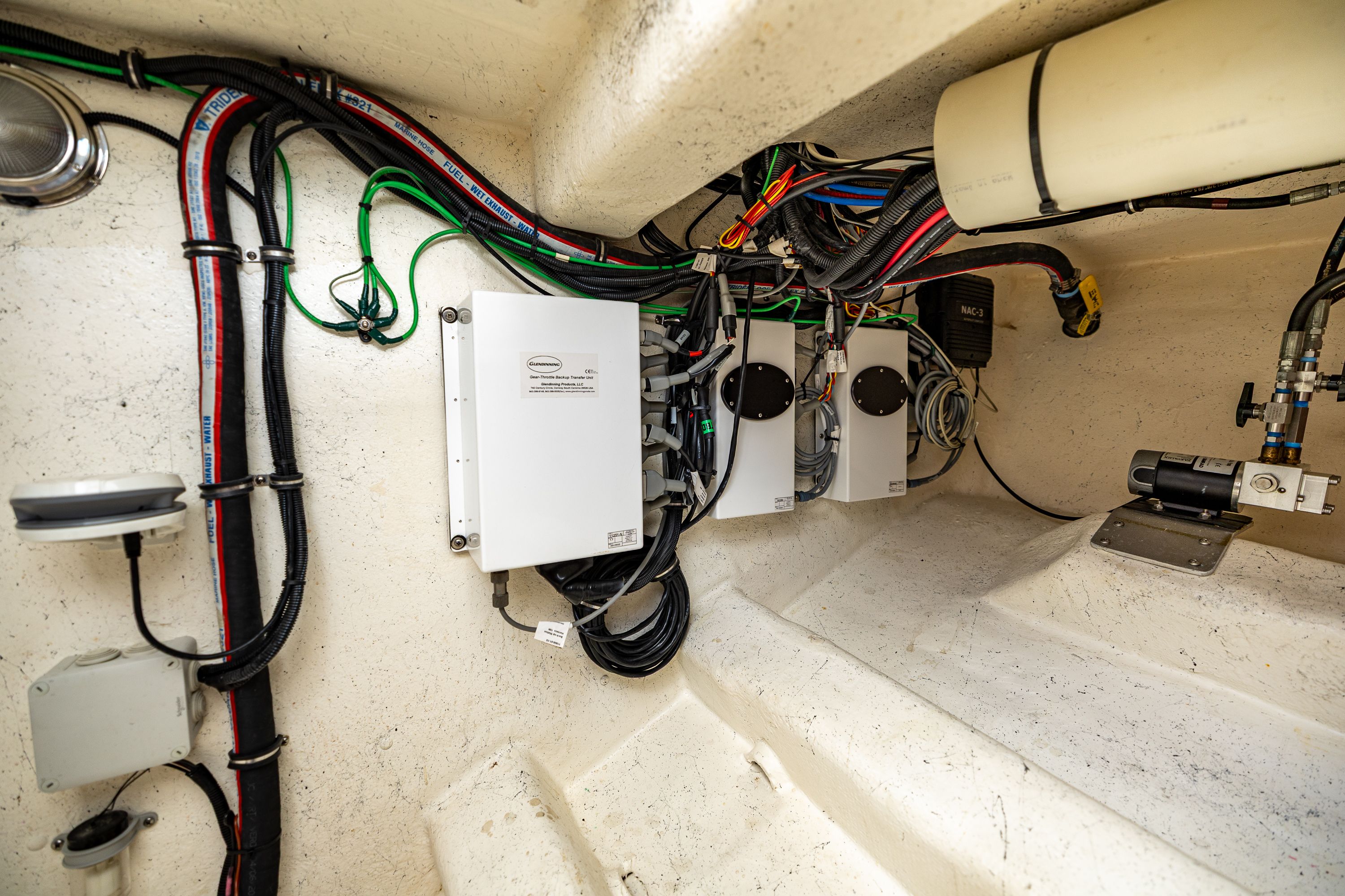 Electrical wiring and equipment inside a boat, featuring various cables and control boxes.