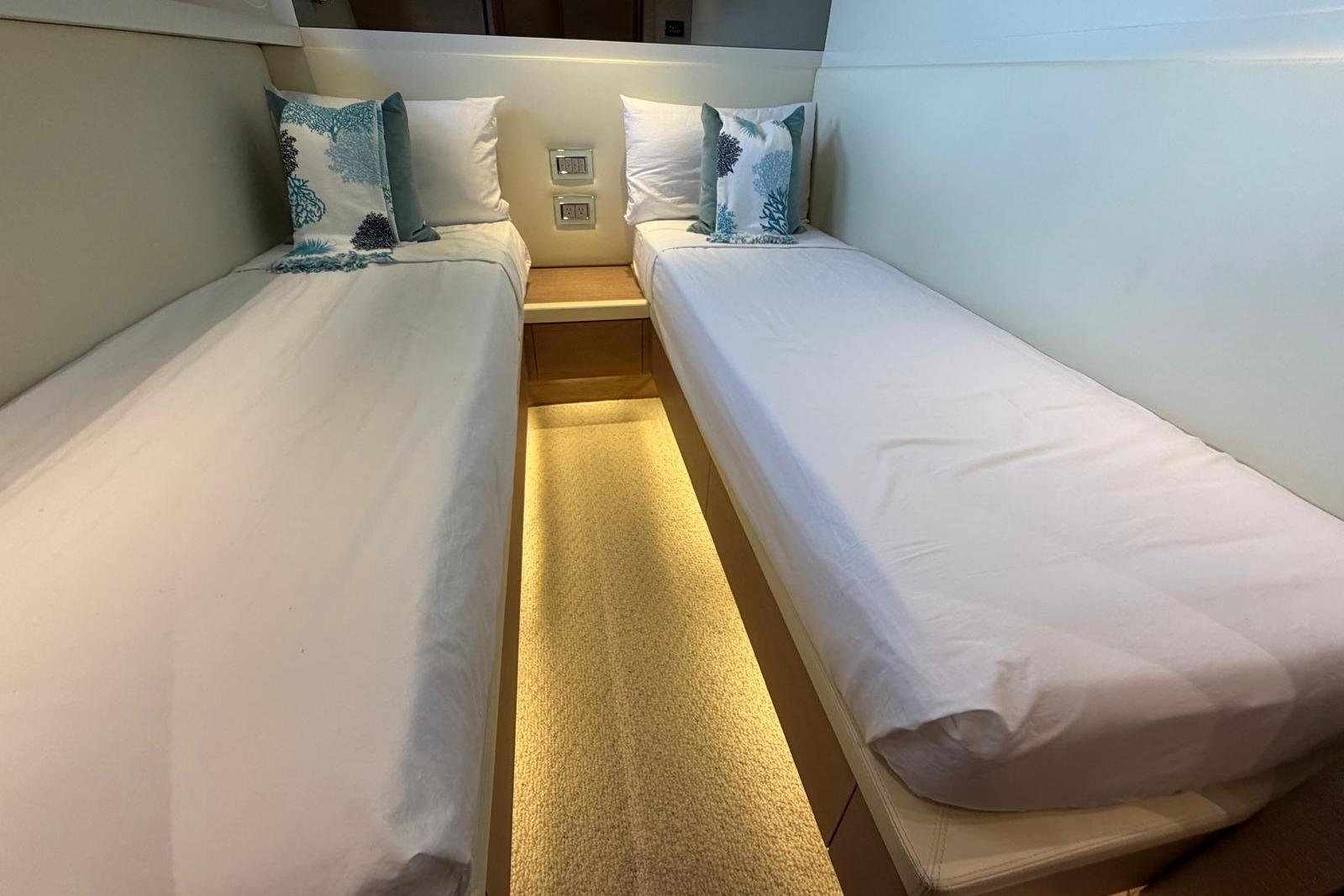 Twin beds in a 2012 Sanlorenzo SL72 yacht cabin with elegant lighting and decor.