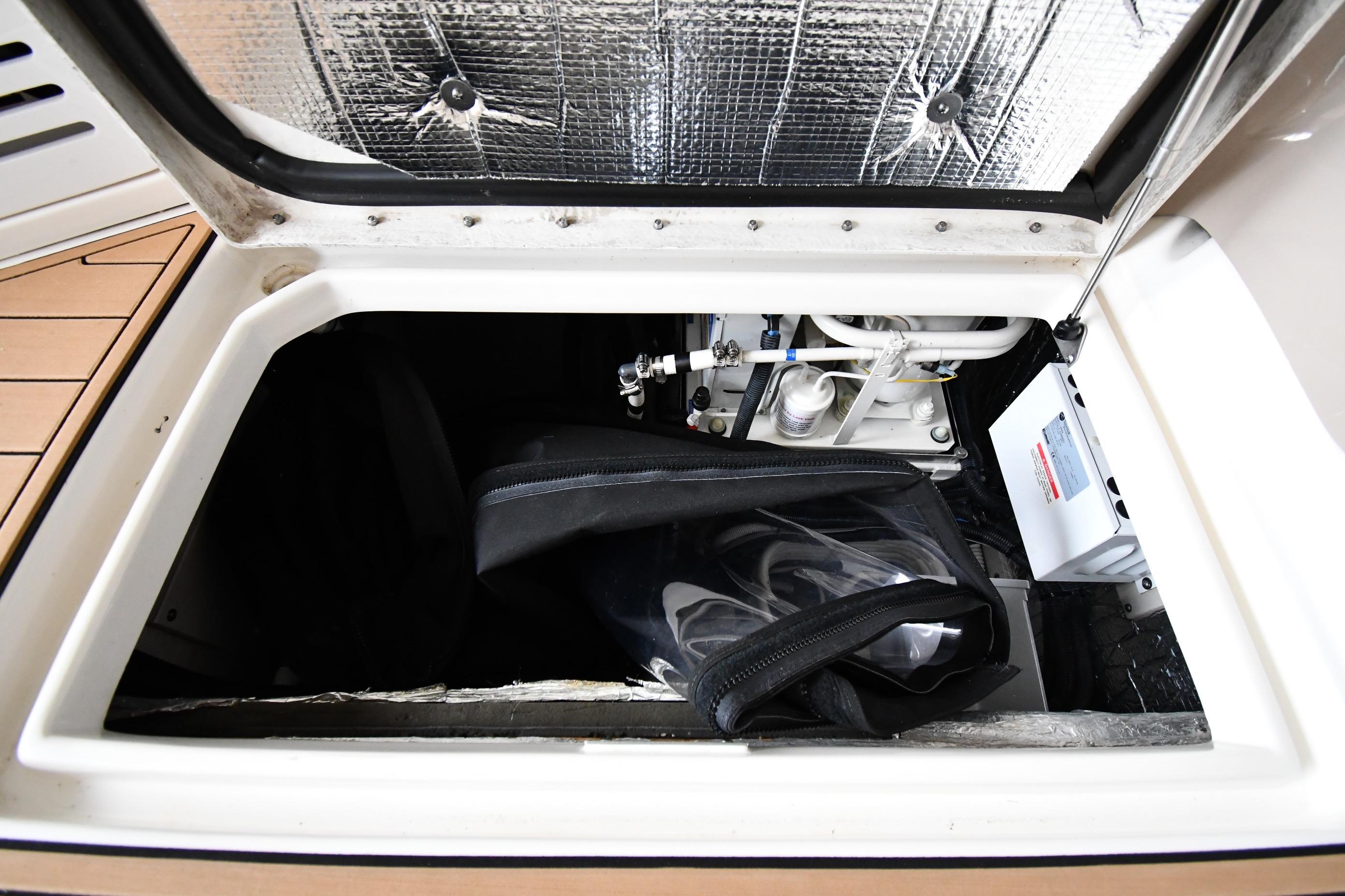 Storage compartment of a 2001 Sea Ray 540 Sundancer boat, showing equipment and insulation.
