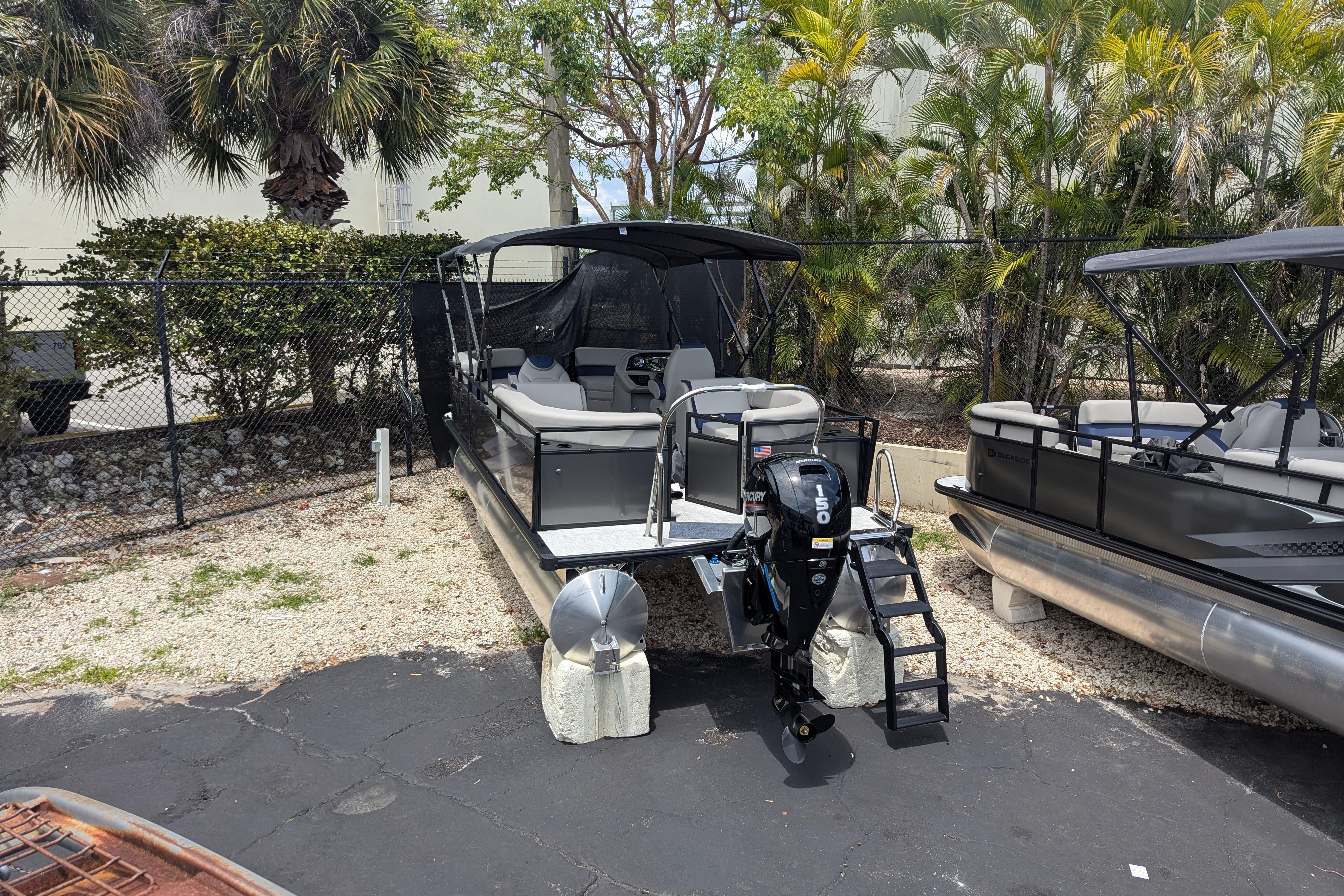 2026 Dockside 22DQ2.75 pontoon boat with outboard motor, parked outdoors.