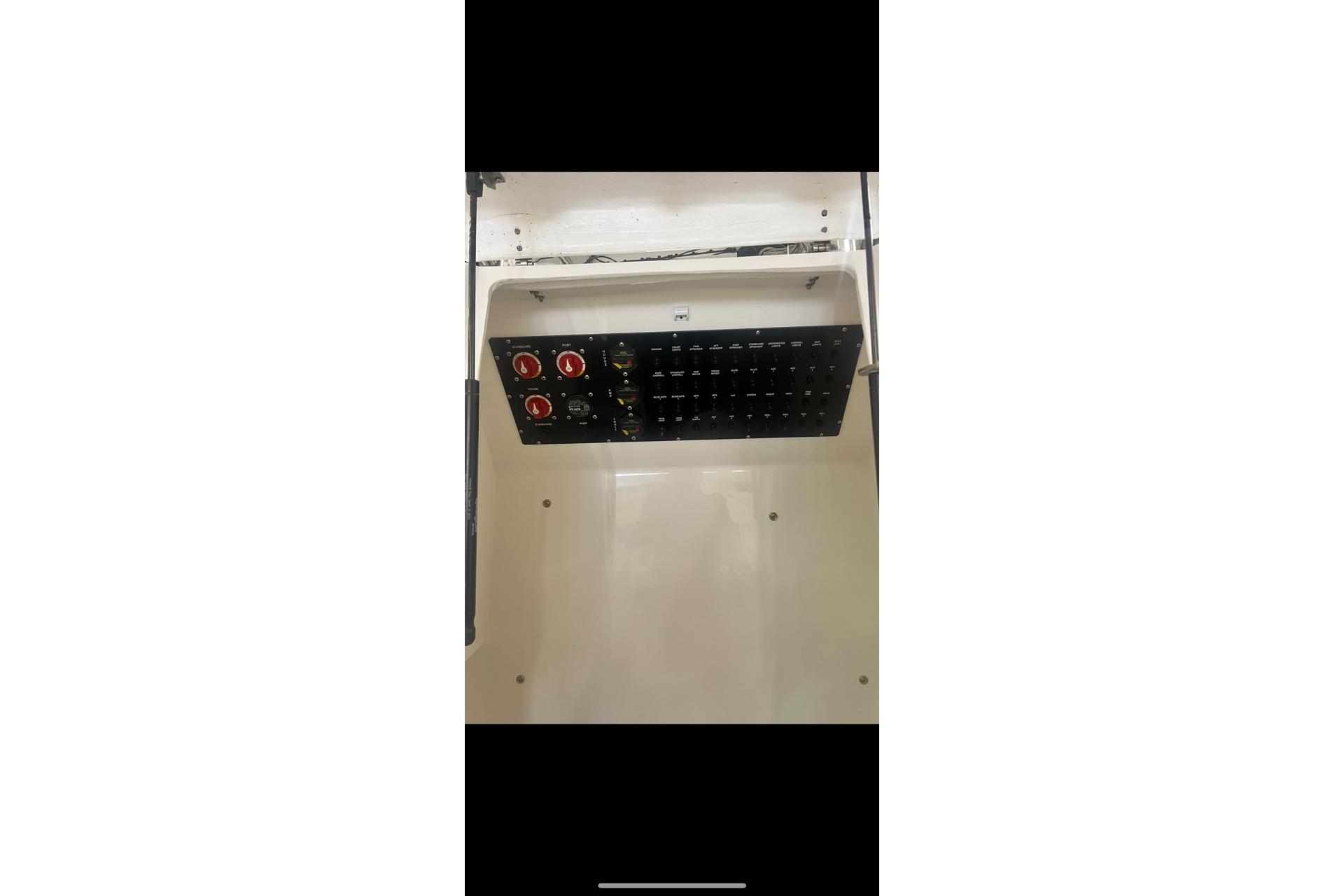 Electrical panel inside 2021 Custom Infusion 34 CC boat, featuring switches and controls.