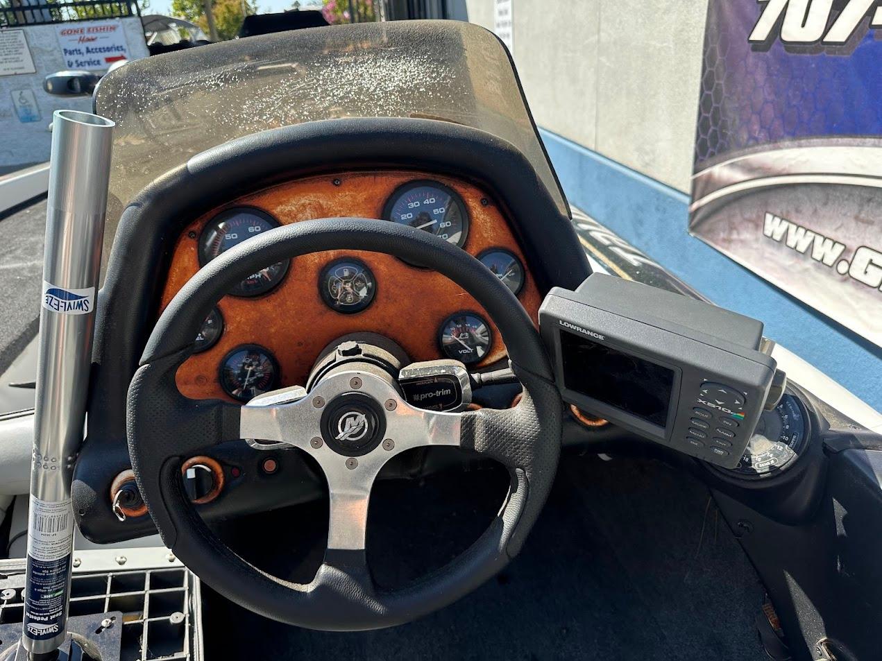 Dashboard of a 1999 Fisher 21 FX DC boat with steering wheel and gauges.