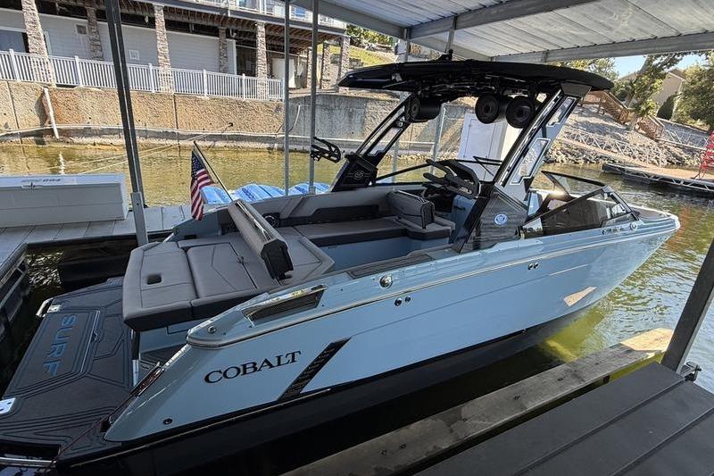 2026 Cobalt R8 Surf boat docked, featuring sleek design and modern amenities.