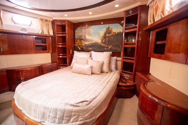 Luxurious bedroom interior of 2003 Azimut 74 Solar yacht with elegant wood finishes.