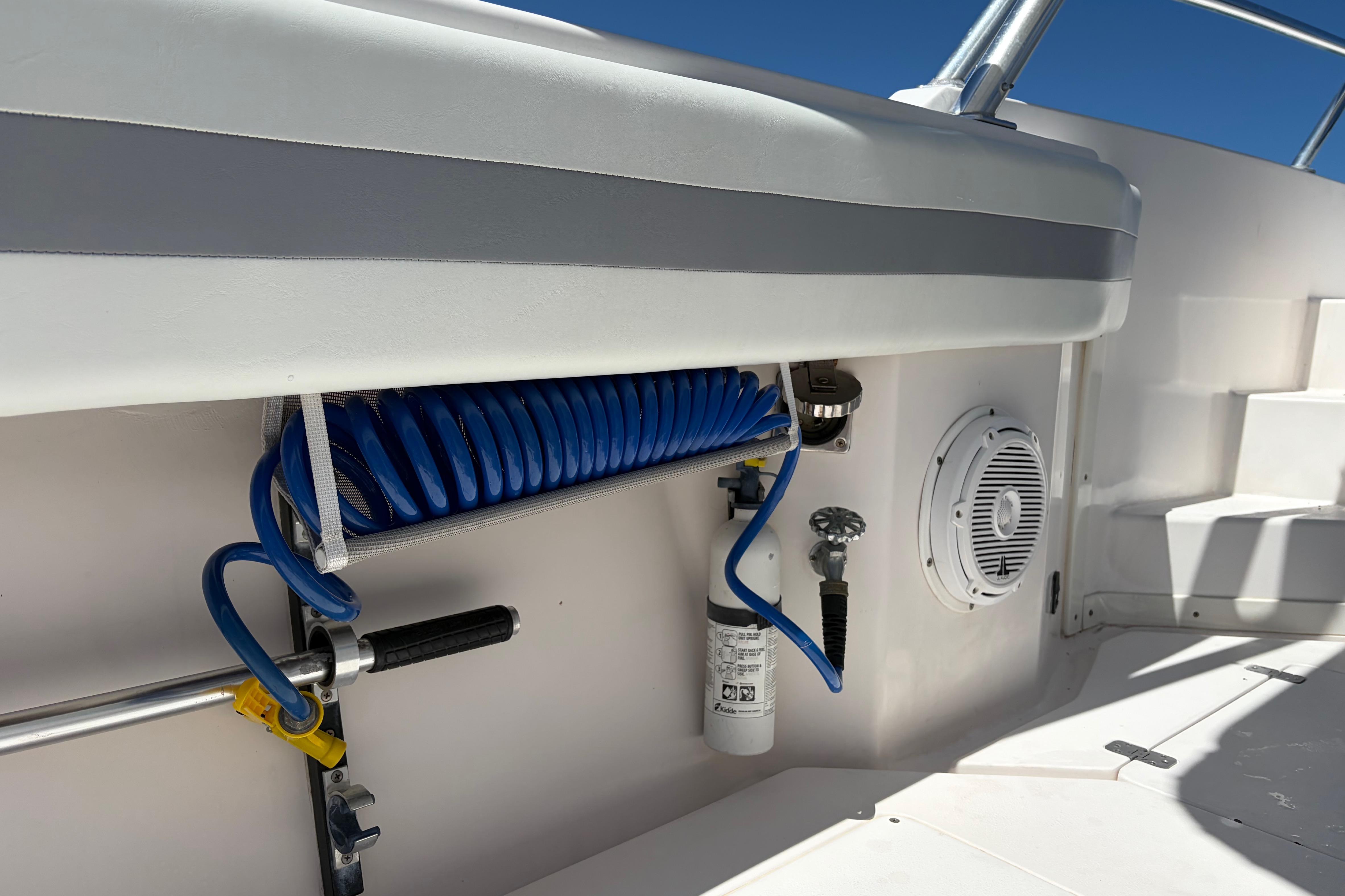 1998 Intrepid 339 Walkaround boat interior with coiled hose and speaker.