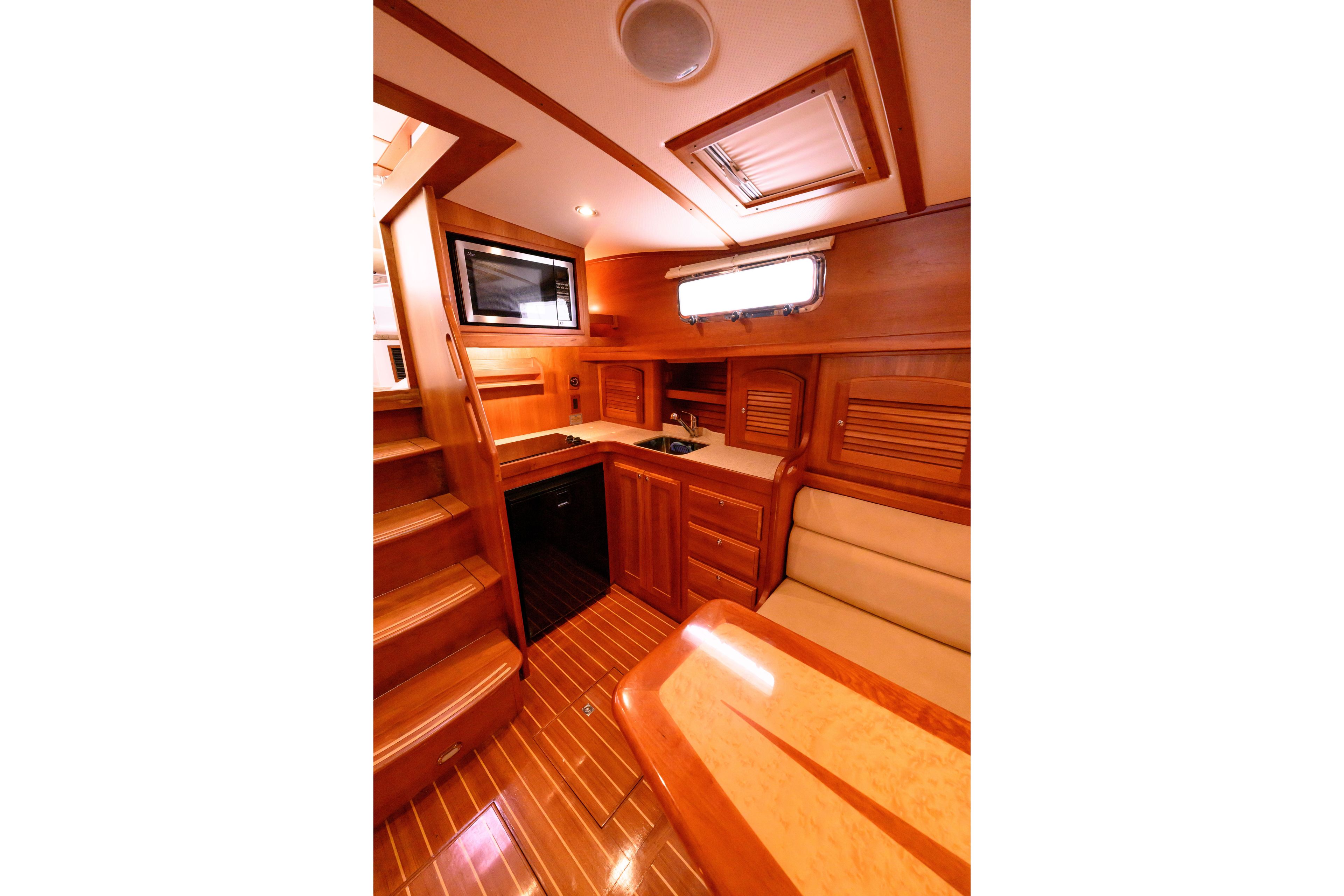 2009 Sabre 42 Hard Top Express interior with wooden cabinetry, seating, and kitchenette.