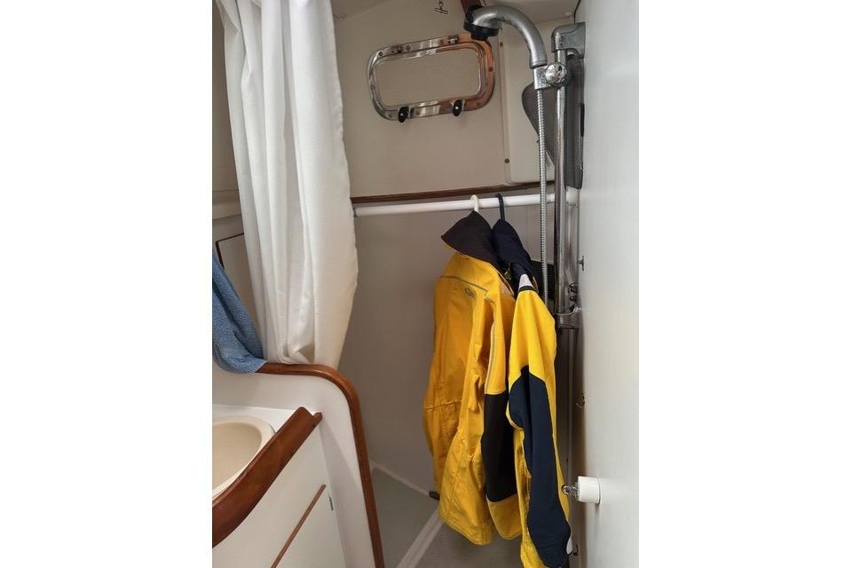 Interior of a 1996 Freedom 35 sailboat bathroom with hanging yellow jackets.