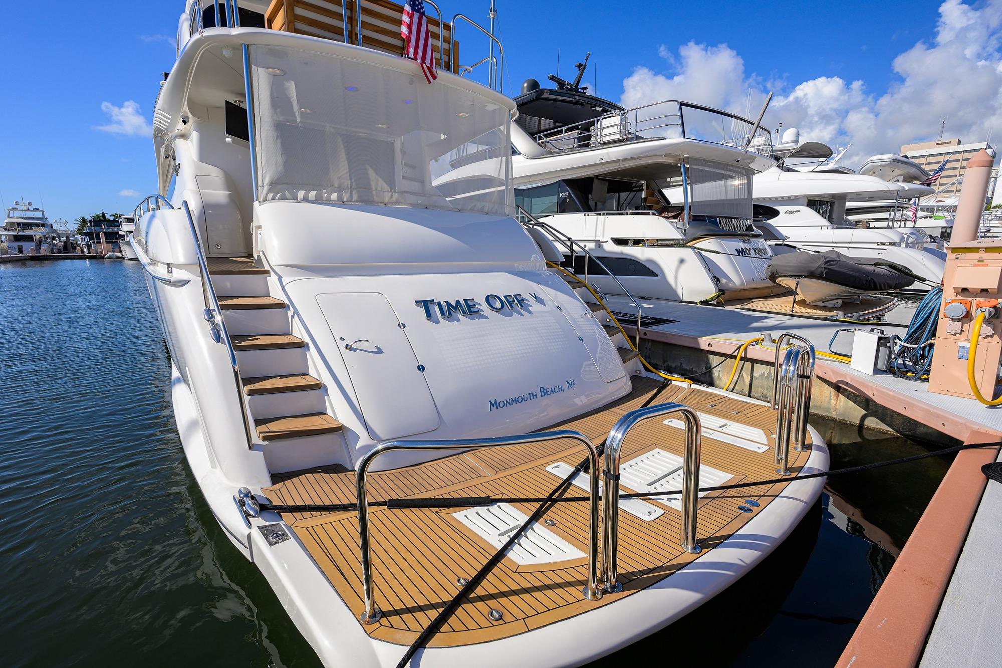 2005 Lazzara 68 Enclosed Bridge yacht docked at marina, sunny day.