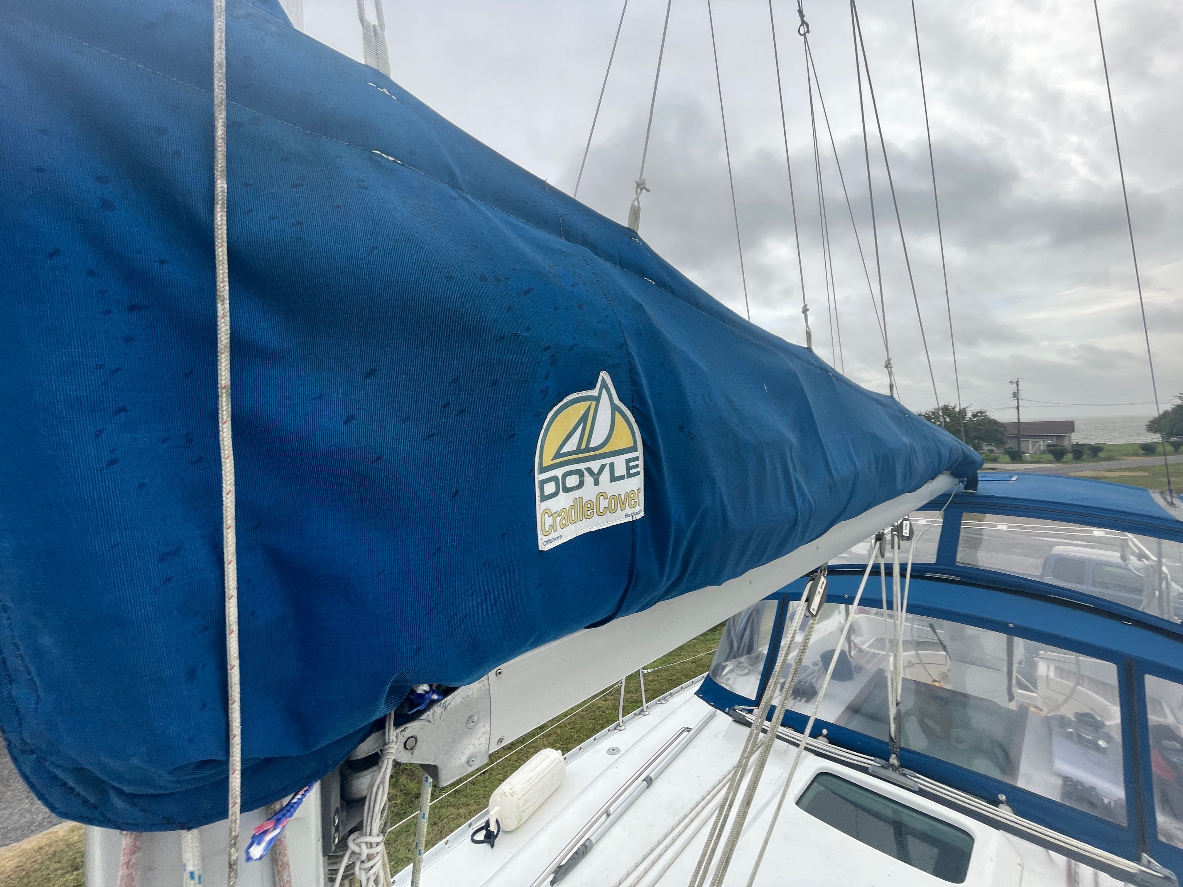 Close-up of a sailboat with a blue sail cover and Doyle logo.