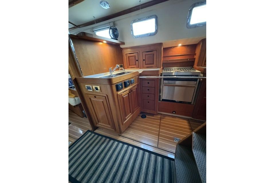 Luxurious wooden interior of 2002 Saga 43 yacht kitchen with modern appliances.