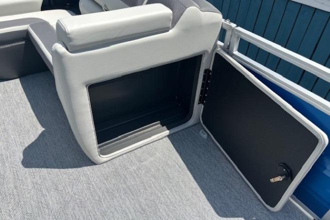 2026 Sun Tracker Fishin' Barge 20 DLX storage compartment with open door and seating.
