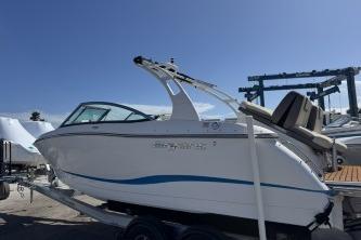 2019 Bryant Calandra 23 boat on trailer under clear blue sky.