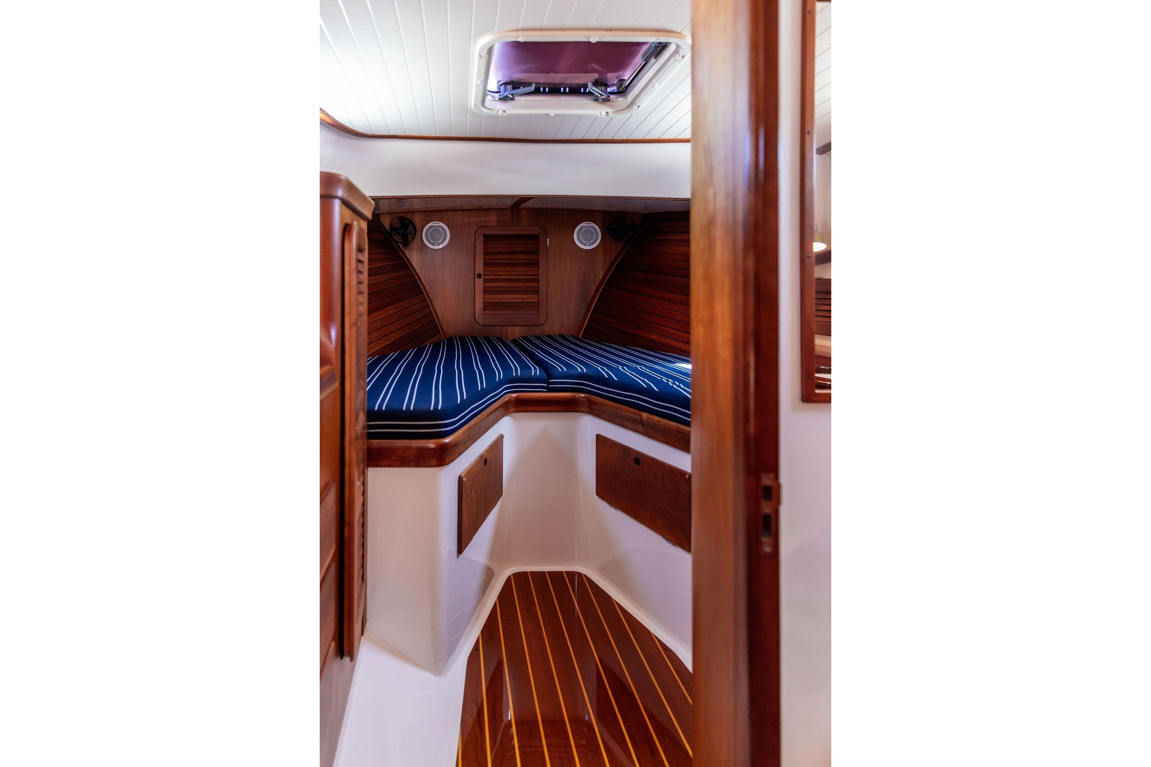 Interior cabin of 2000 Hinckley Picnic Boat 36 Classic with striped cushions and wood finish.