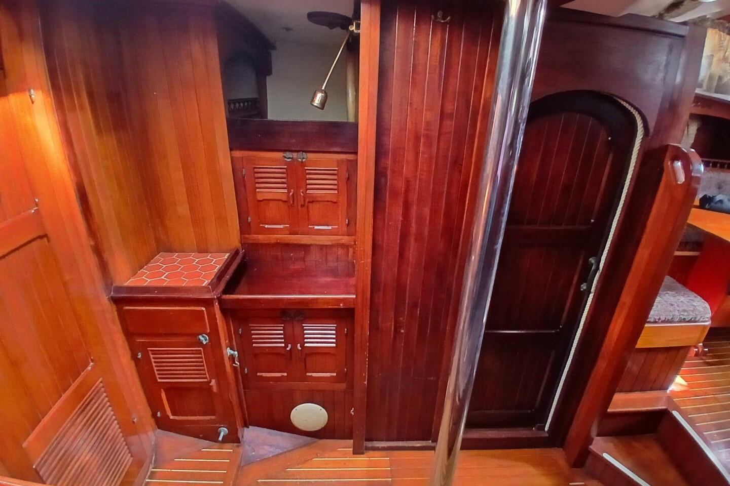 Interior of 1980 Hardin 45 sailboat with rich wooden cabinetry and flooring.