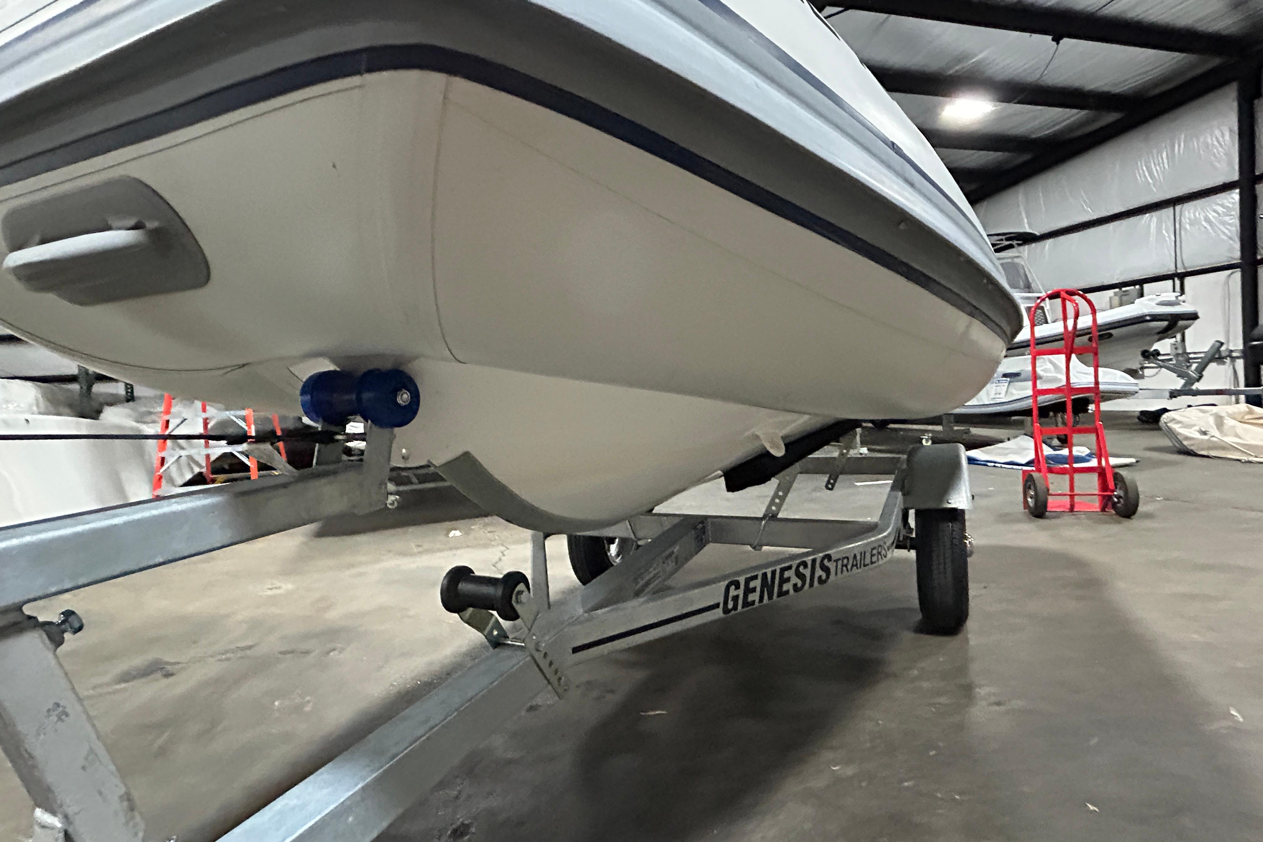 2023 Highfield Classic 310 boat on Genesis trailer in warehouse setting.