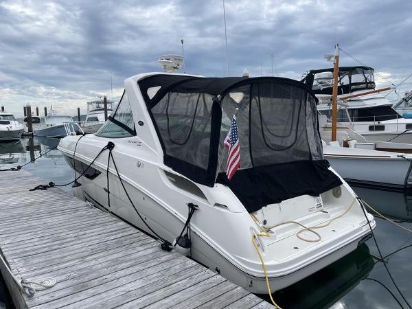 2014 Sea Ray 310 Sundancer docked at marina with American flag.