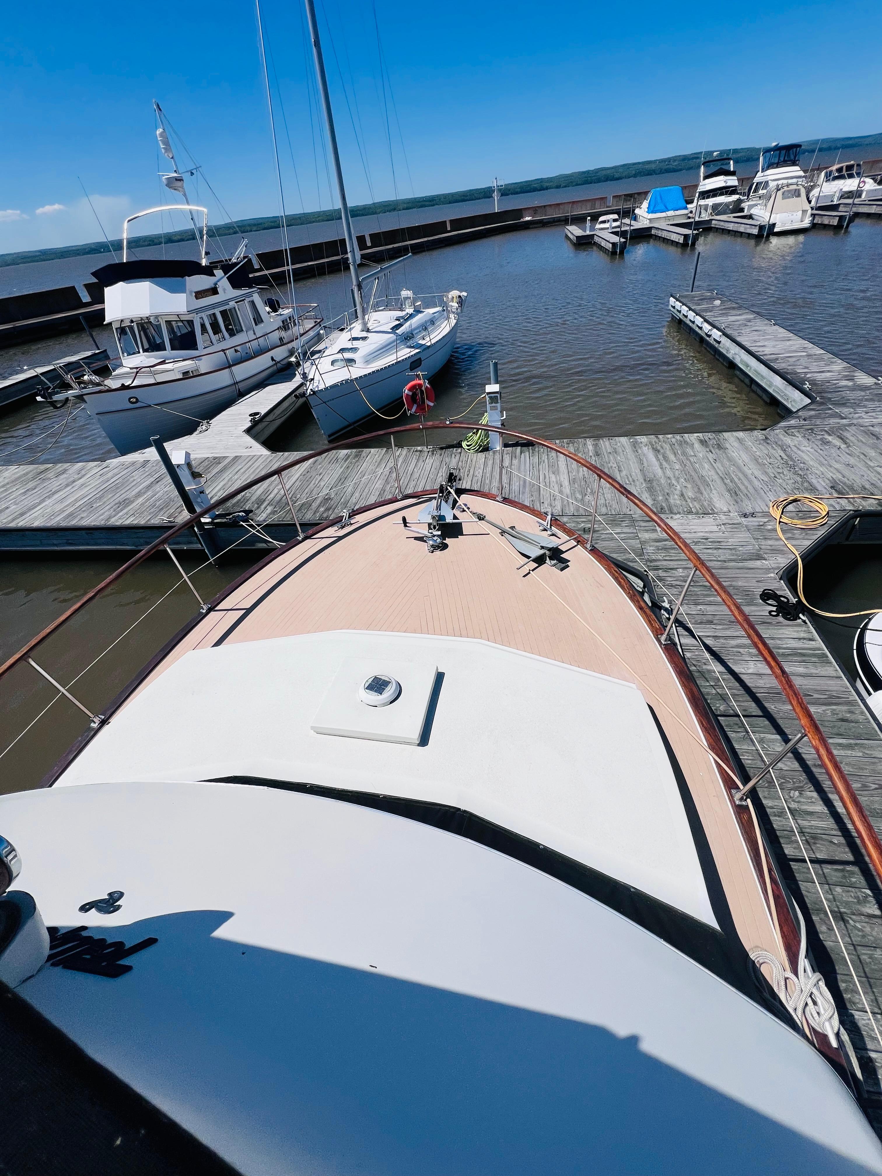 1974 Tollycraft 40 Tri-Cabin Motoryacht docked at a marina under clear blue skies.