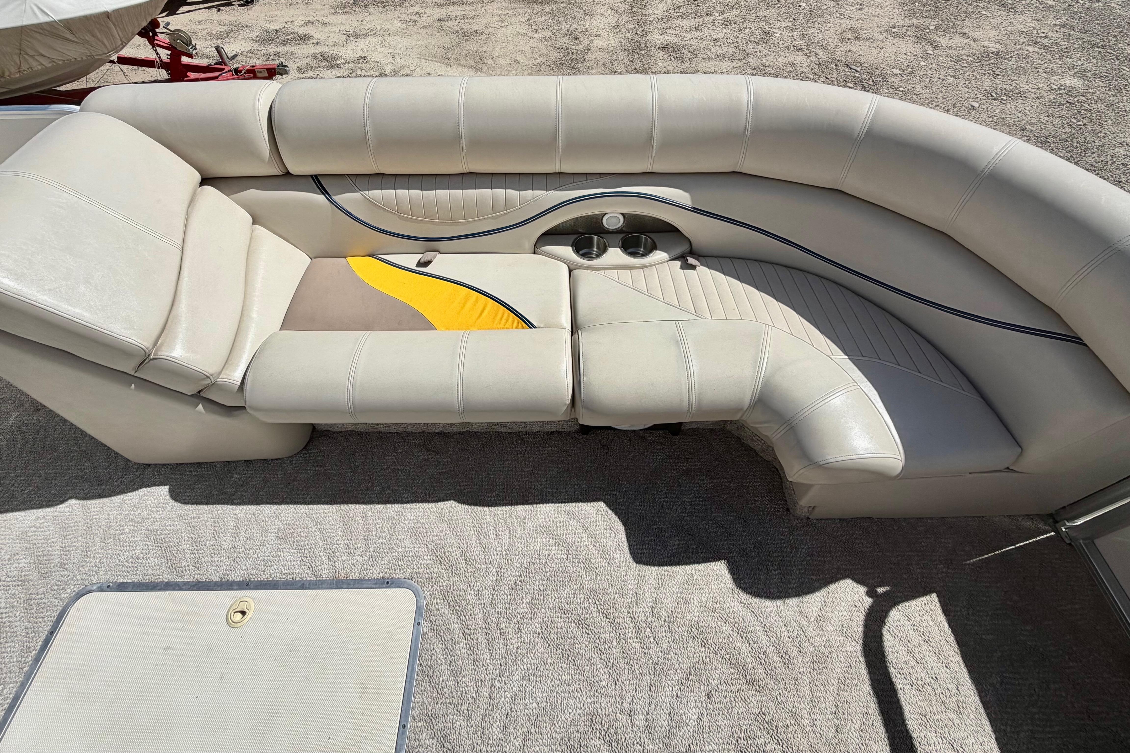 2006 South Bay 925CR pontoon boat interior with beige seating and cup holders.