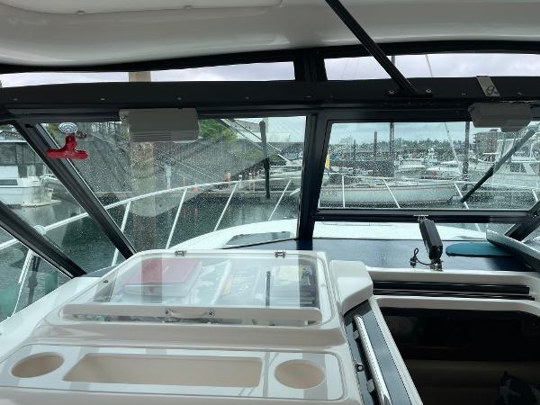 Interior view of 2003 Tiara Yachts 3500 Open, showcasing helm and marina backdrop.