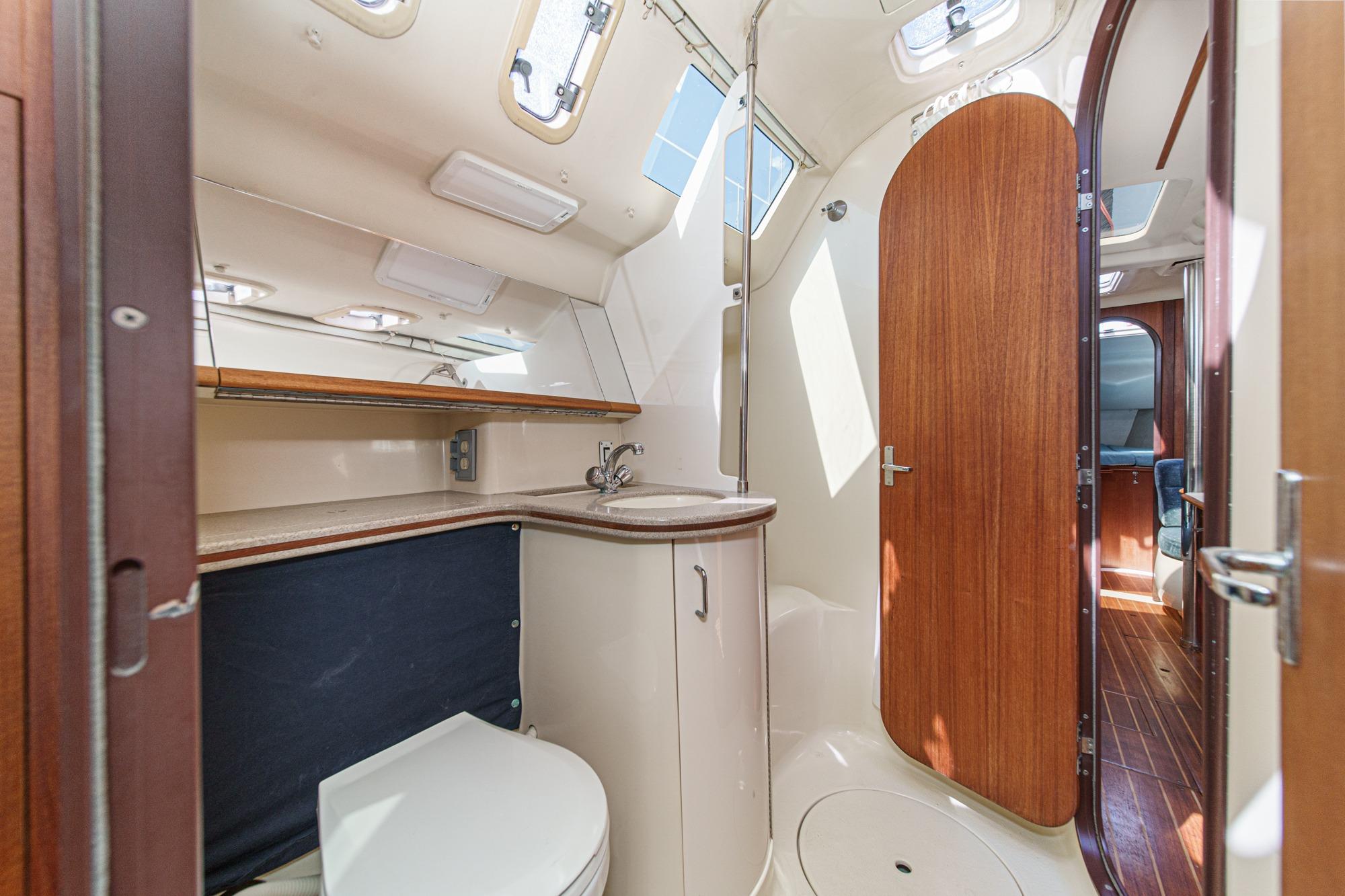 Interior of 1996 Hunter 376 sailboat bathroom with wooden door and compact design.