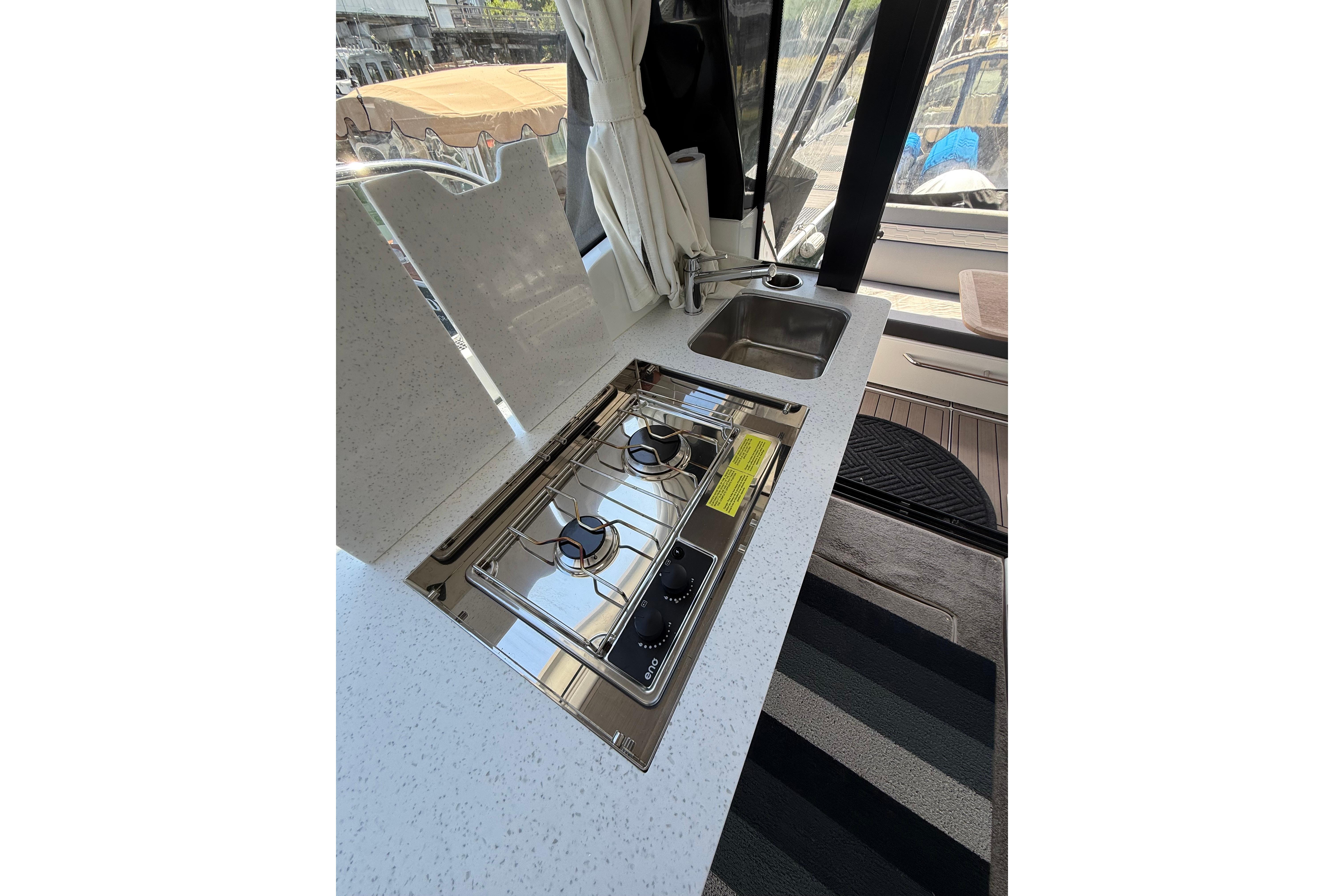 2024 Jeanneau NC 1095 Coupe kitchen with stove and sink.