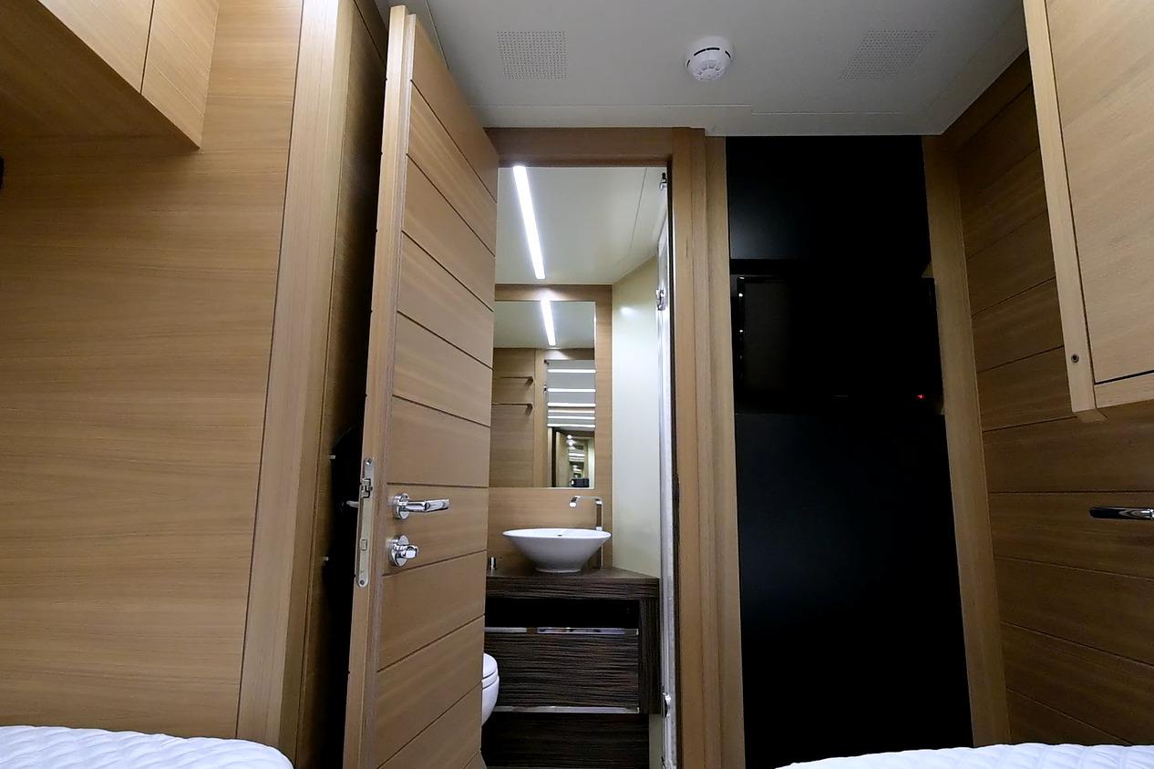 Luxurious interior of 2015 Pershing 92 yacht featuring modern wood paneling and sleek bathroom design.