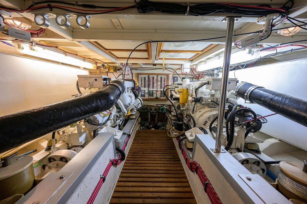 Engine room of a 1999 Grand Banks 42 Europa yacht, showcasing dual engines and mechanical systems.
