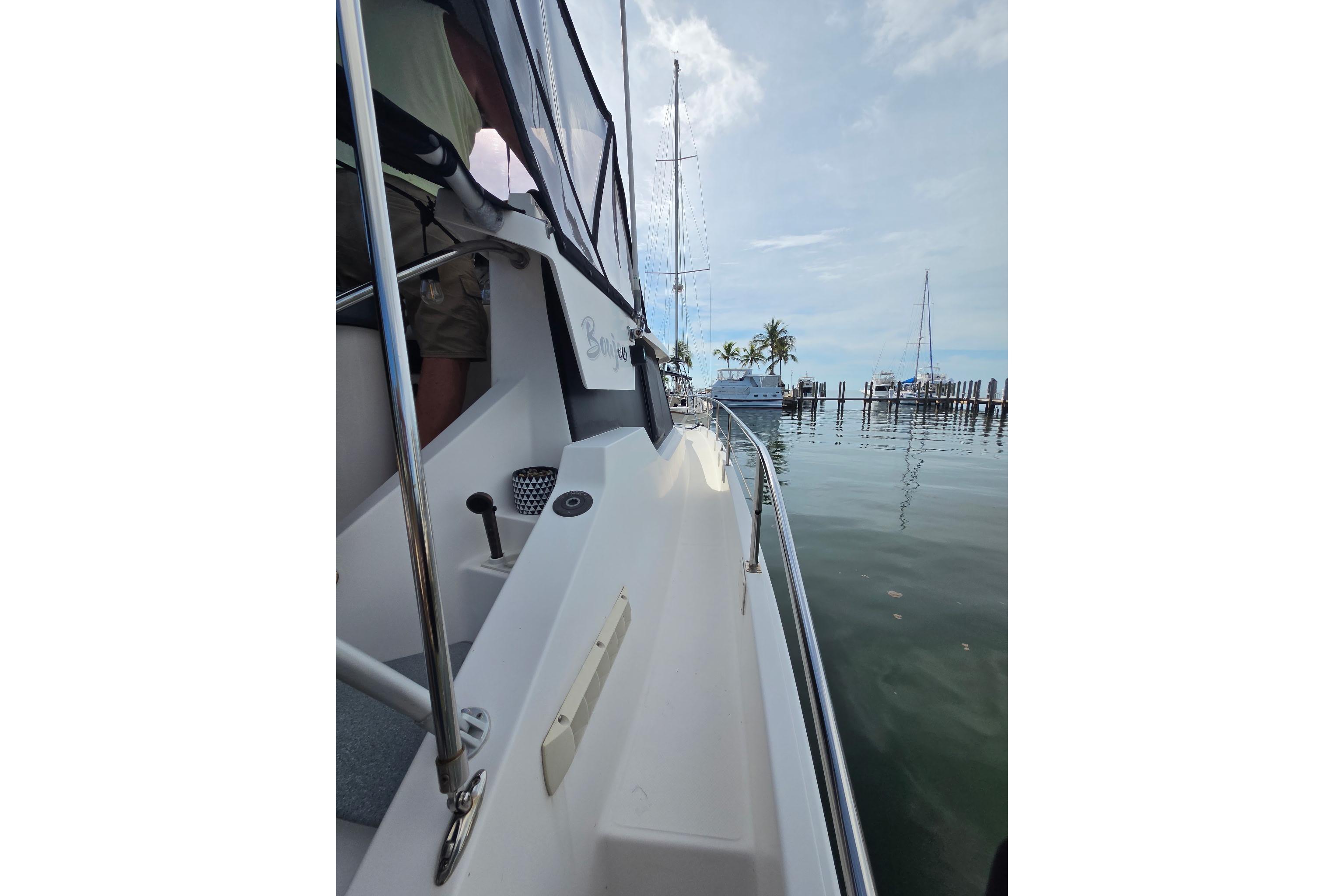2000 Fountaine Pajot Maryland 37 yacht docked, calm waters, palm trees in background.