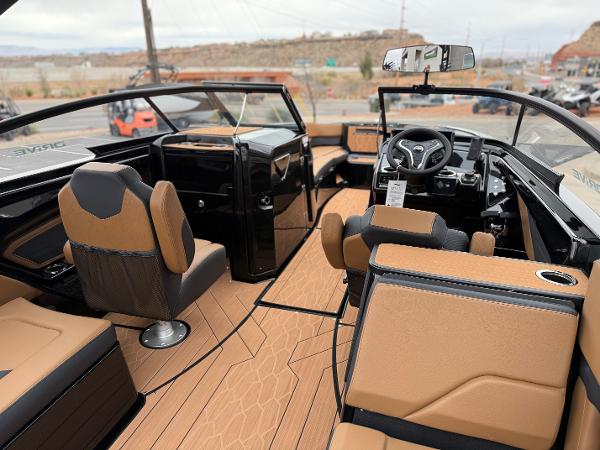 2025 Yamaha Boats 255XD interior with tan and black seating, modern dashboard, and sleek design.