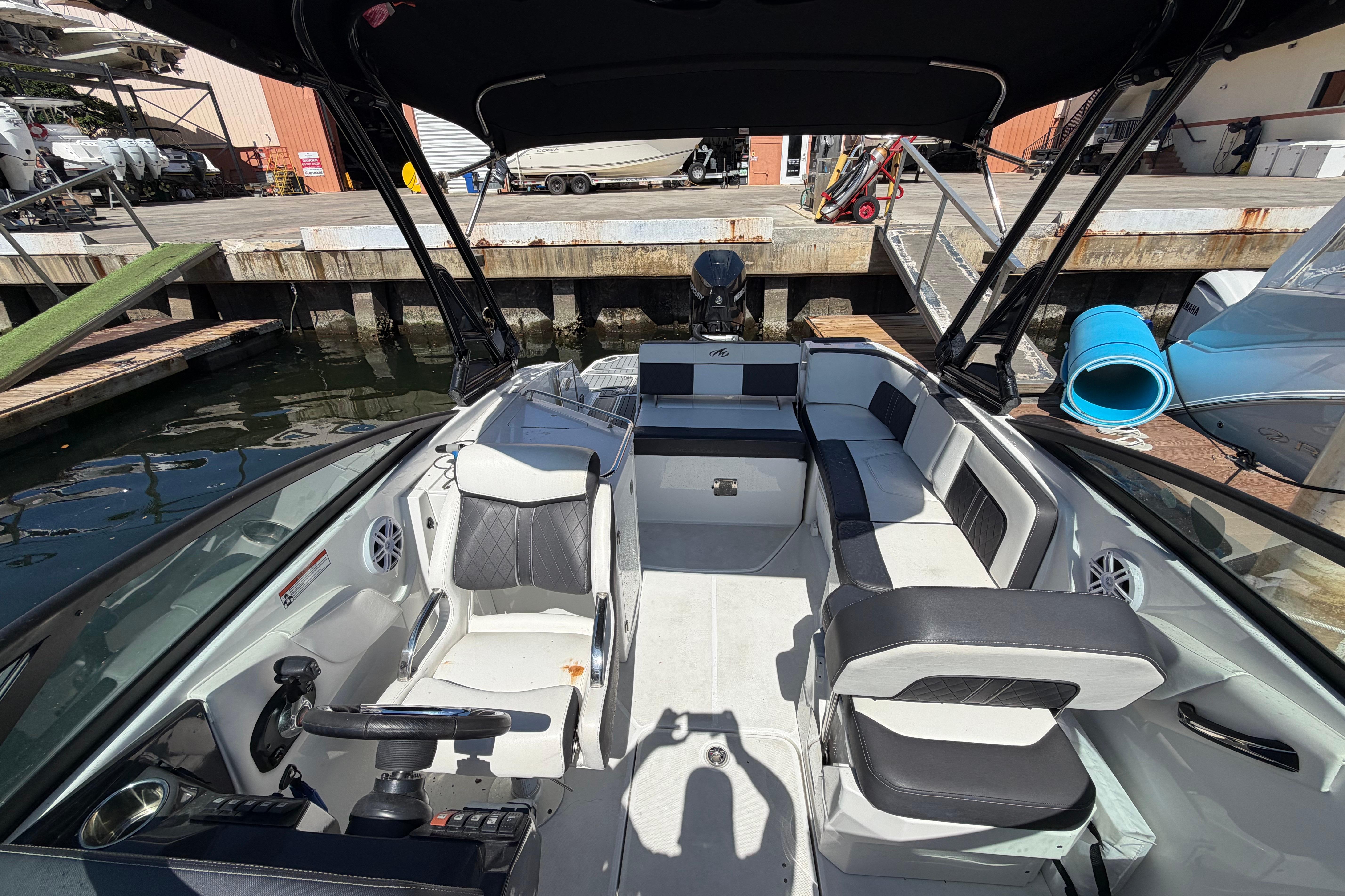 2022 Monterey M-65 boat interior with seating and steering wheel at a dock.