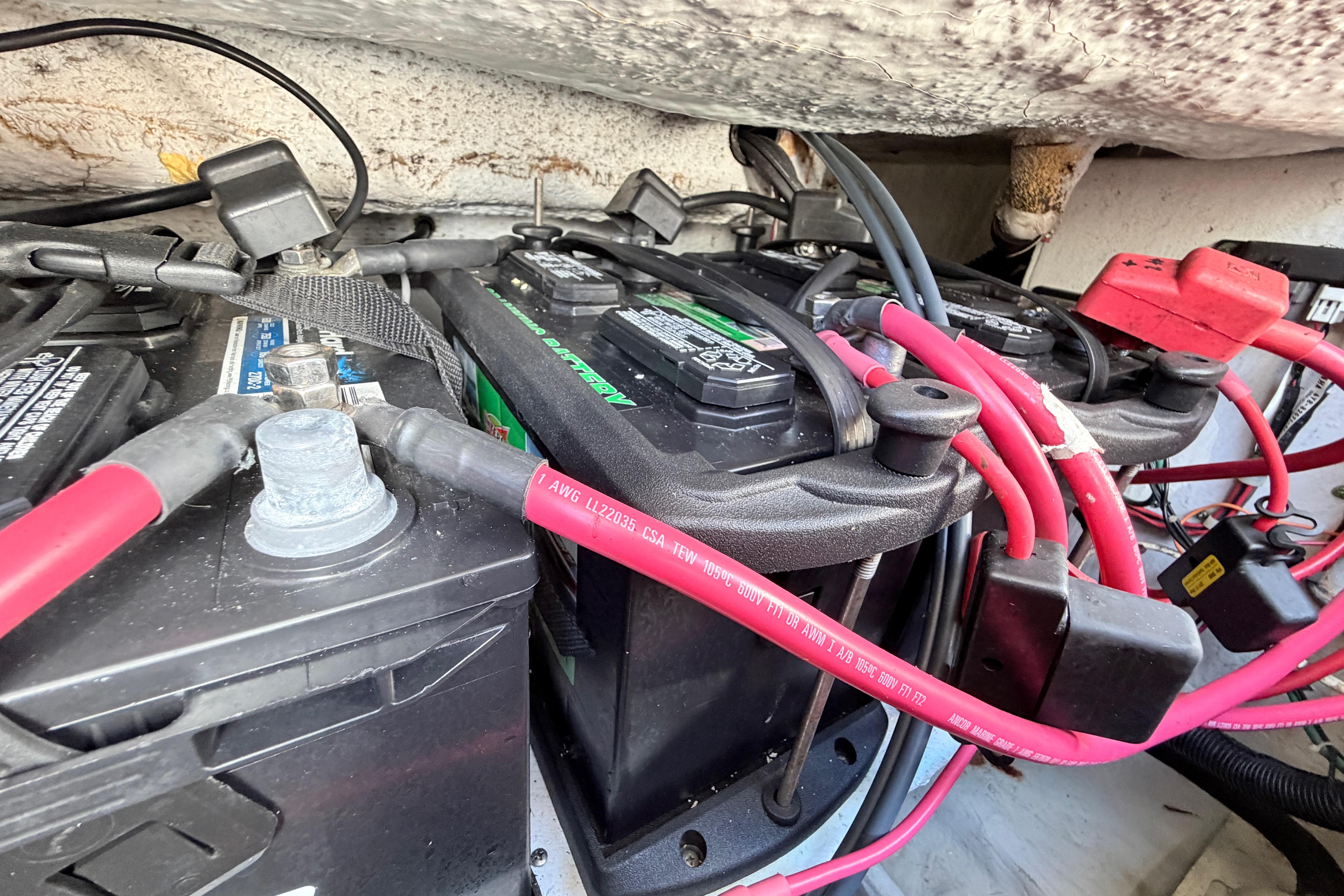Battery compartment of 2006 Grady-White Sailfish 282 with red cables and connectors.