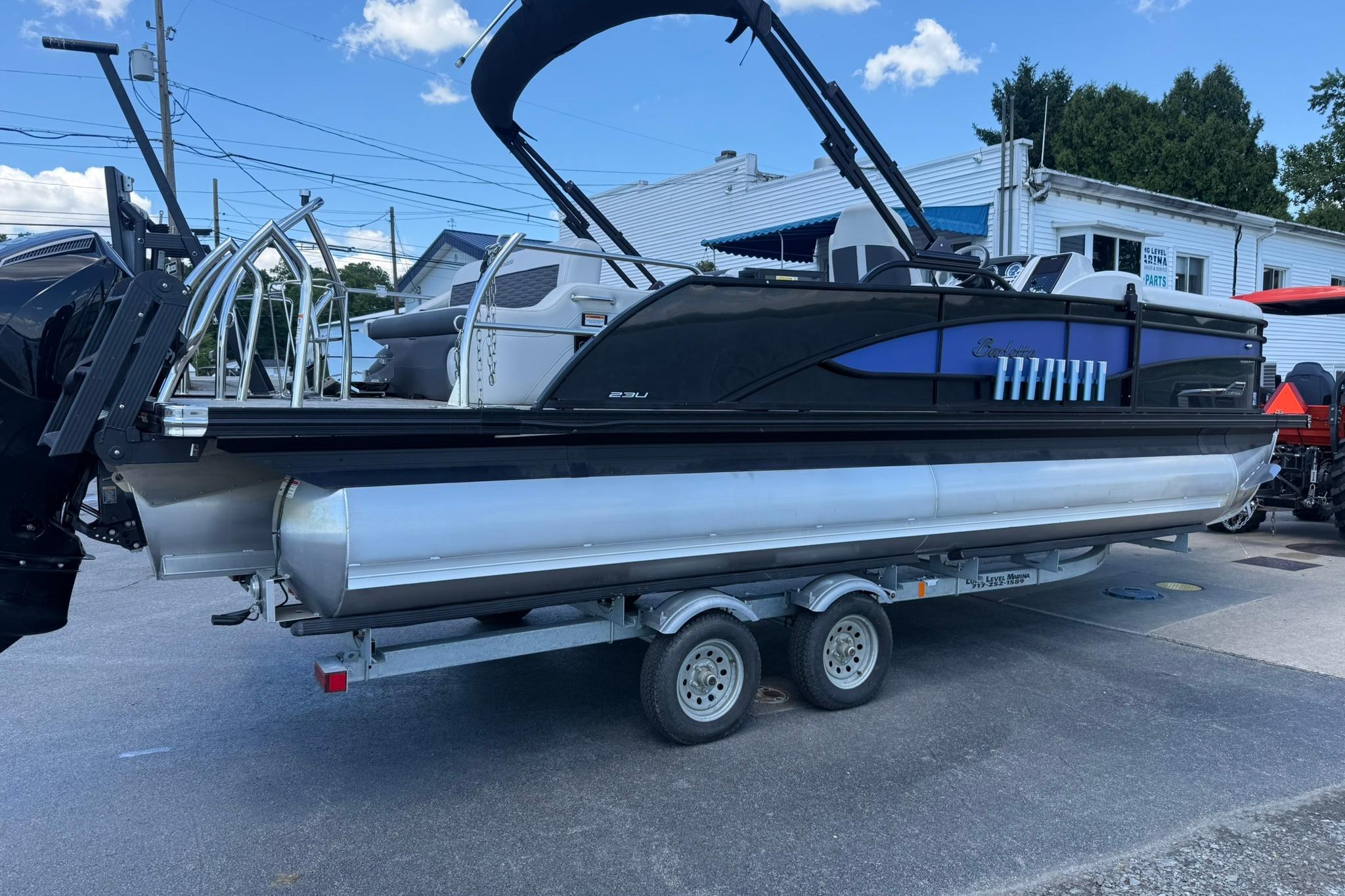 2023 Barletta Corsa 23U pontoon boat on trailer, sleek design, outdoor setting.