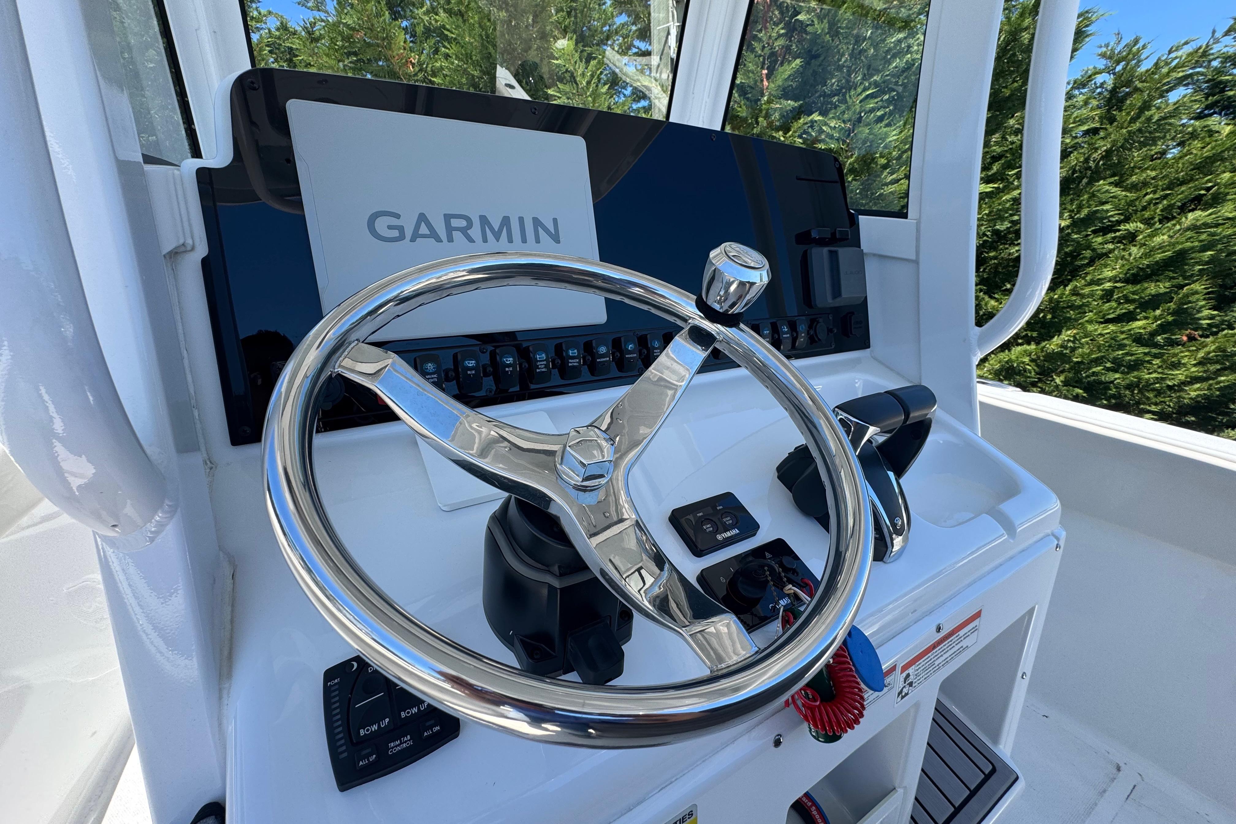 2023 Sea Hunt Gamefish 25 helm with Garmin display and stainless steel steering wheel.