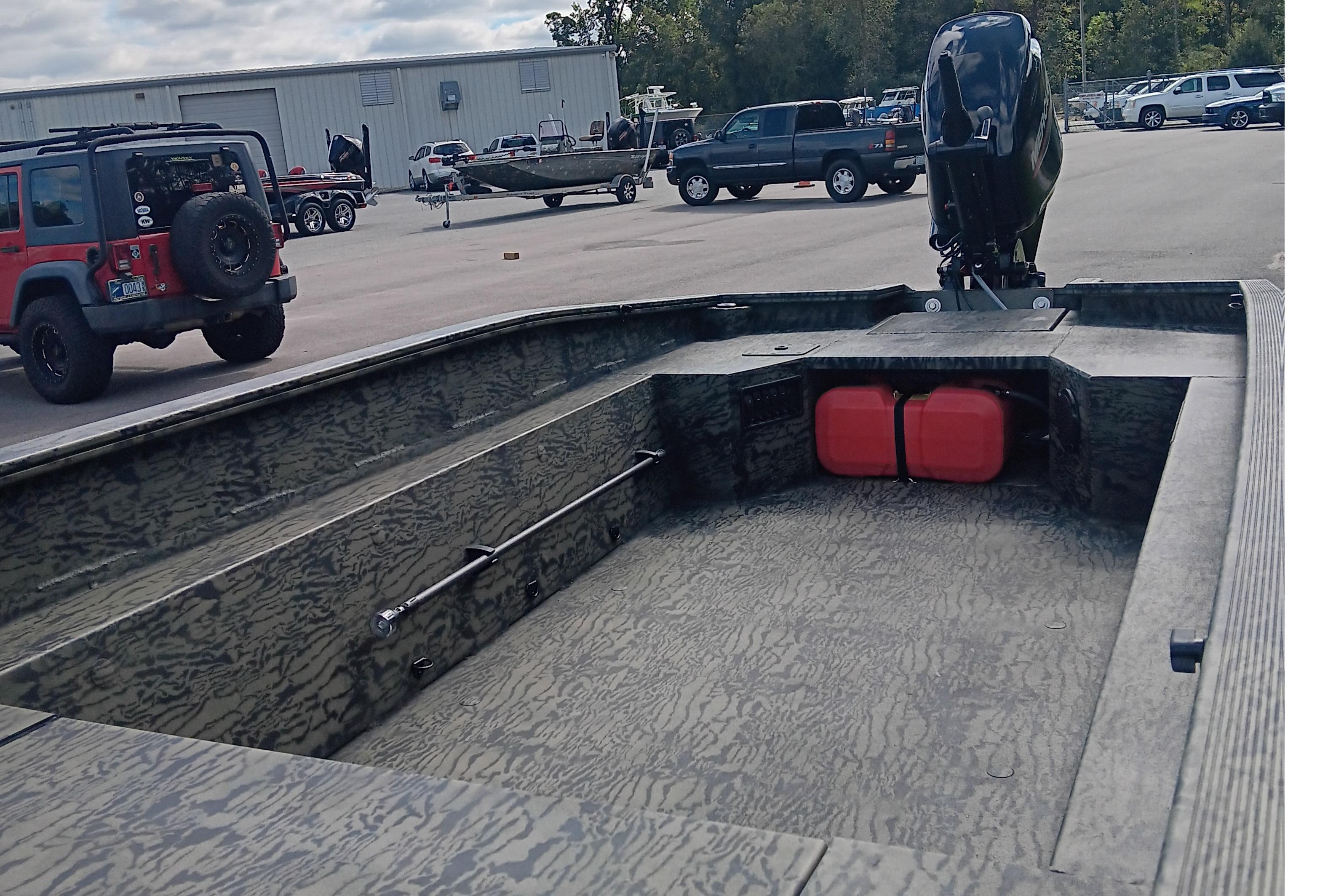 2026 Tracker Grizzly 1650 T Prairie Wings Edition boat in parking lot with vehicles.