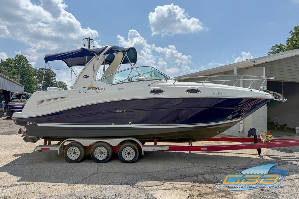 2006 Sea Ray Sundancer 260 boat on trailer, parked outdoors under a cloudy sky.