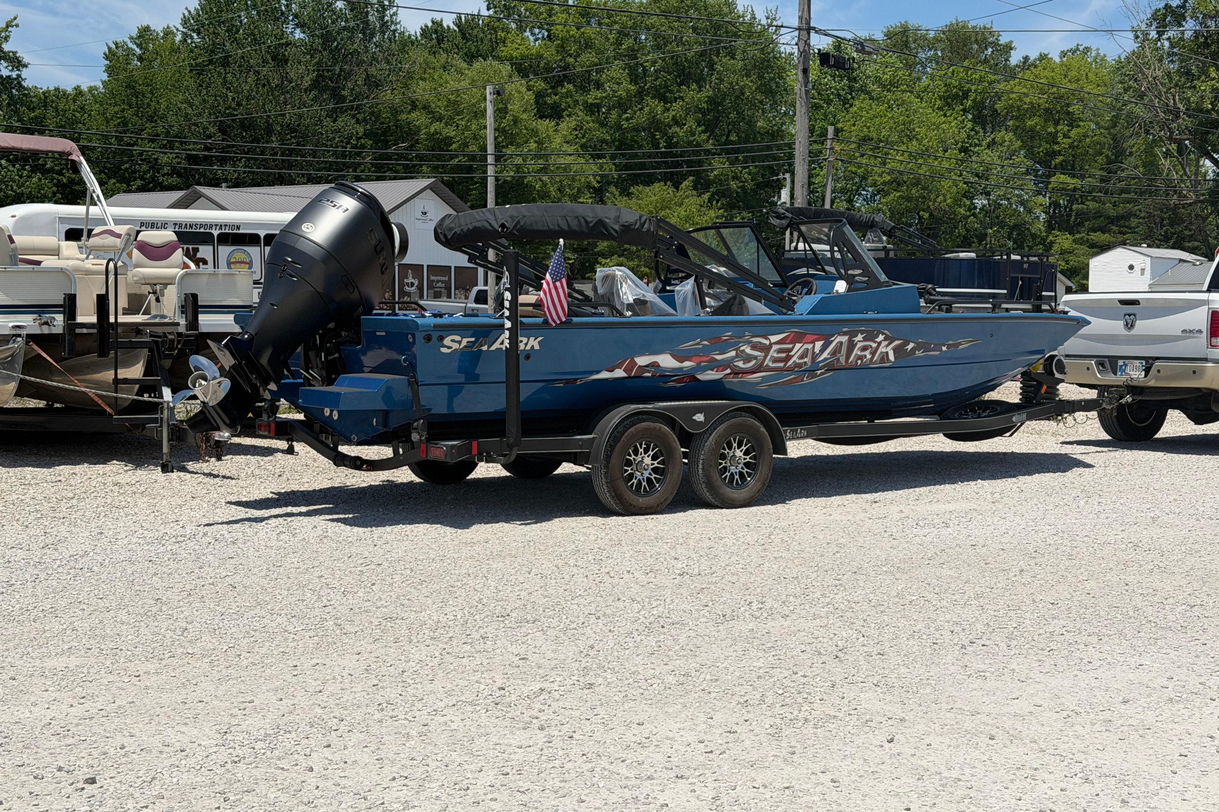 2025 SeaArk Protege 240 boat on trailer, parked outdoors, with trees in the background.