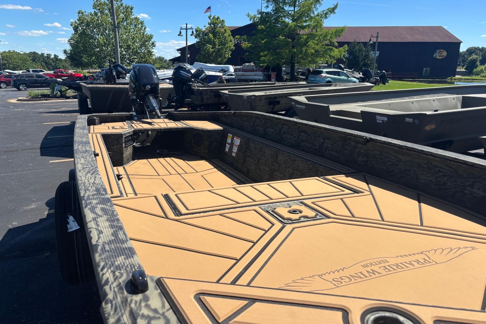 2026 Tracker Grizzly 1650 T Prairie Wings Edition boat in parking lot, sunny day.