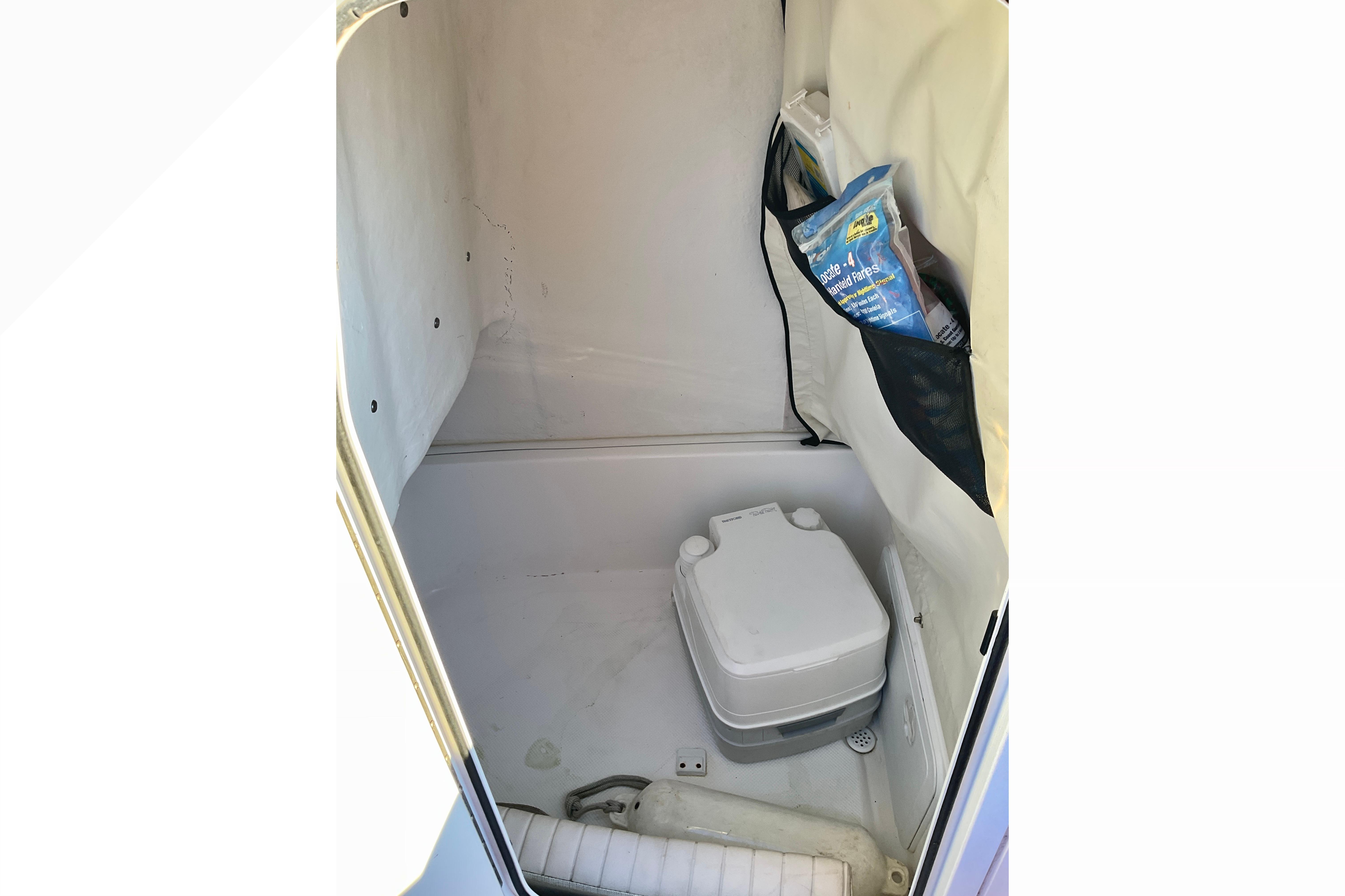 Interior of 2016 Sea Fox 226 Commander boat with portable toilet and storage.