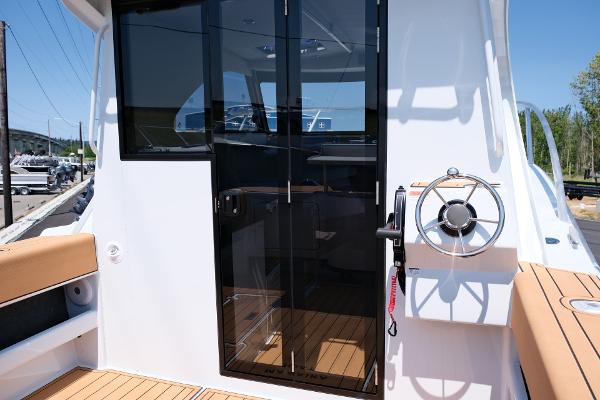 2023 Makaira Gen3 800 boat interior with glass door and steering wheel.