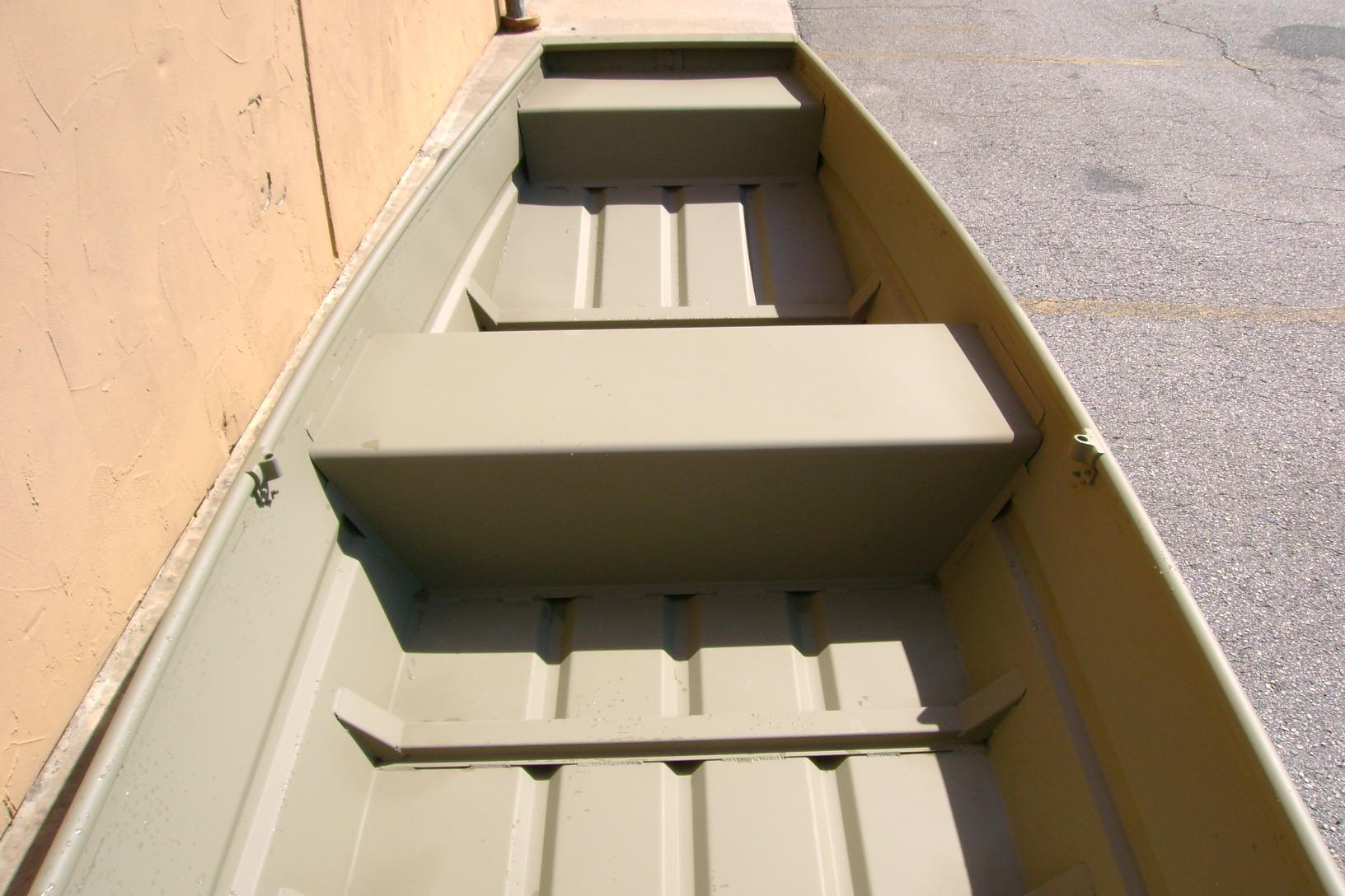 2026 Tracker Grizzly 14 Jon boat interior with bench seats, parked on pavement.