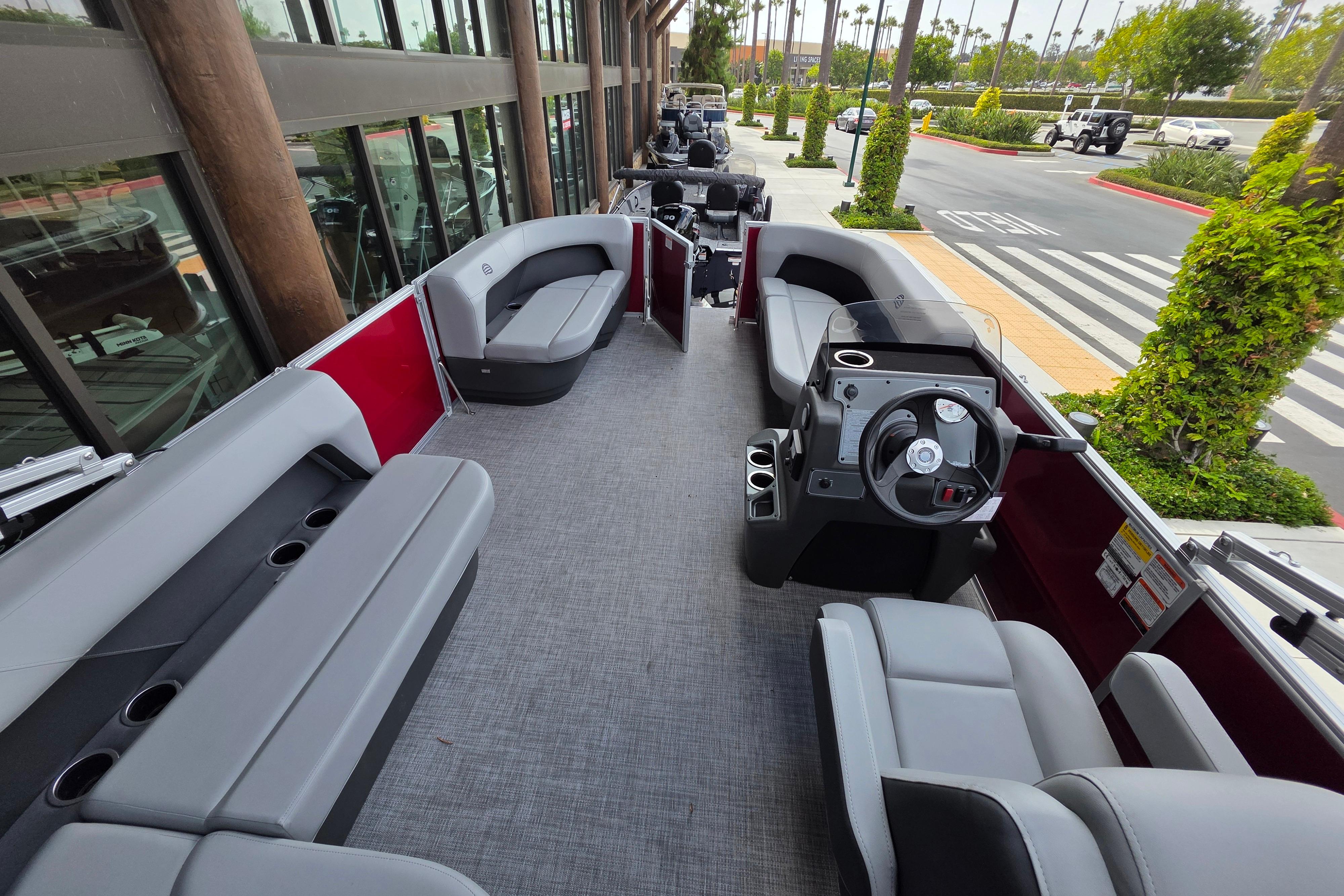 2026 Sun Tracker Party Barge 16 DLX pontoon boat interior with seating and steering console.