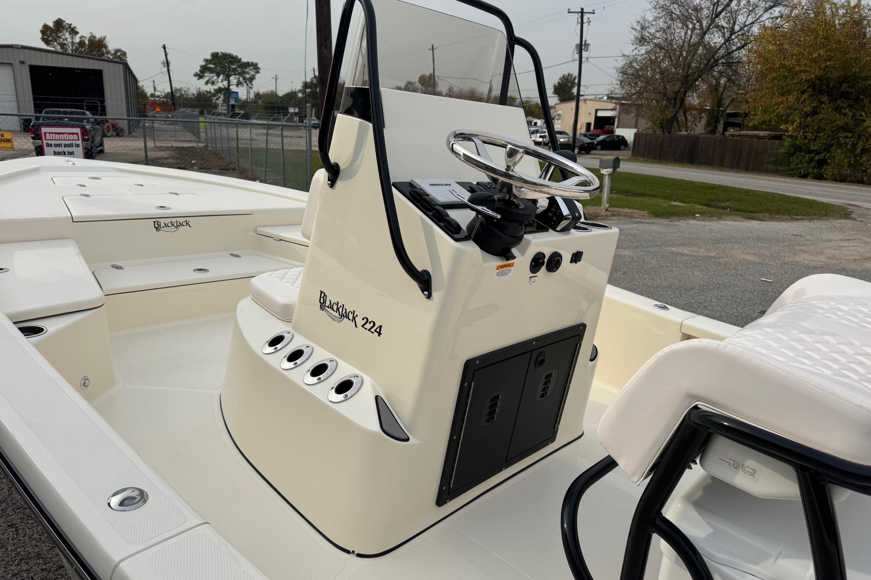 2026 BlackJack 224 boat with steering console, parked outdoors.