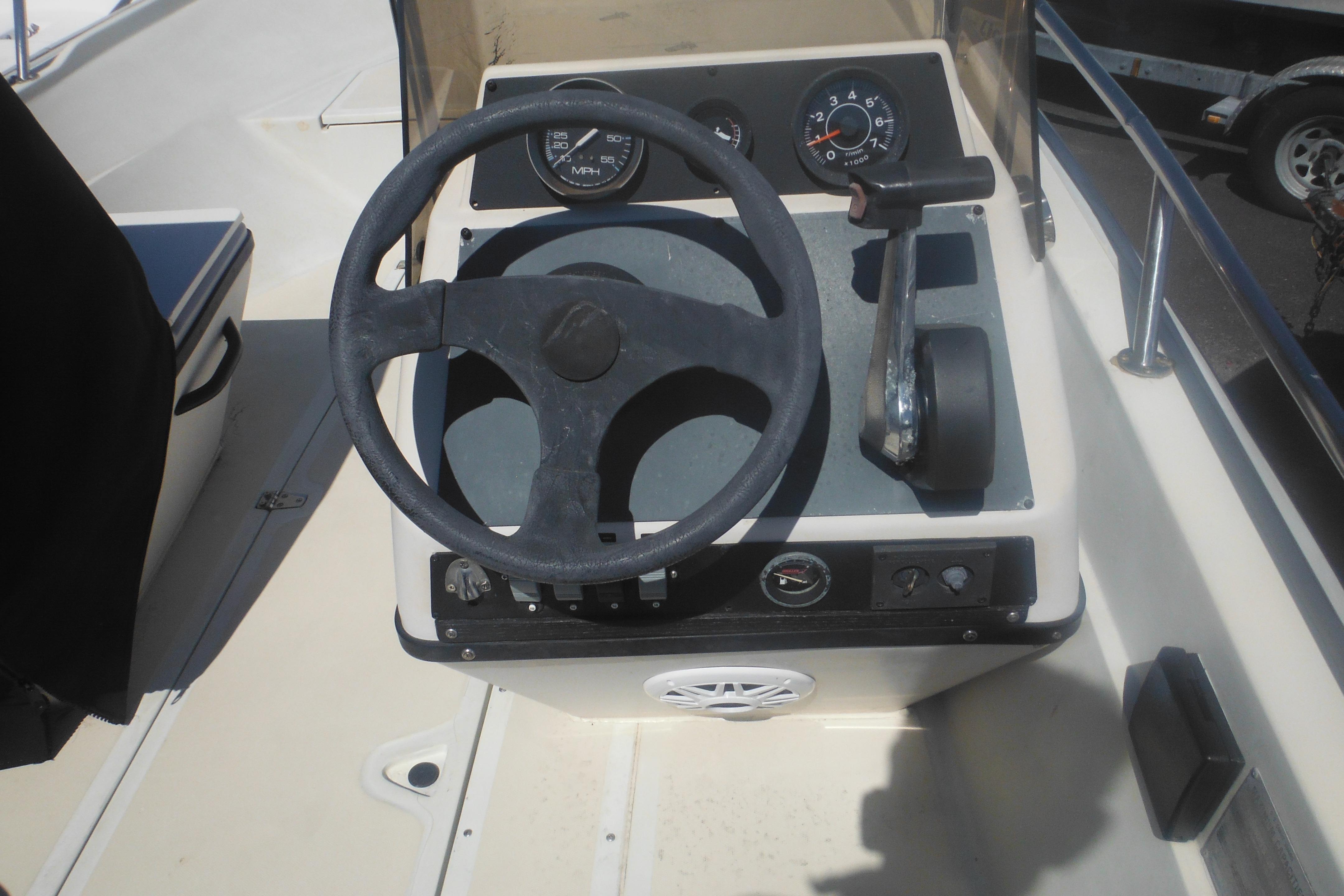 1991 Boston Whaler 16 SL boat dashboard with steering wheel and controls.