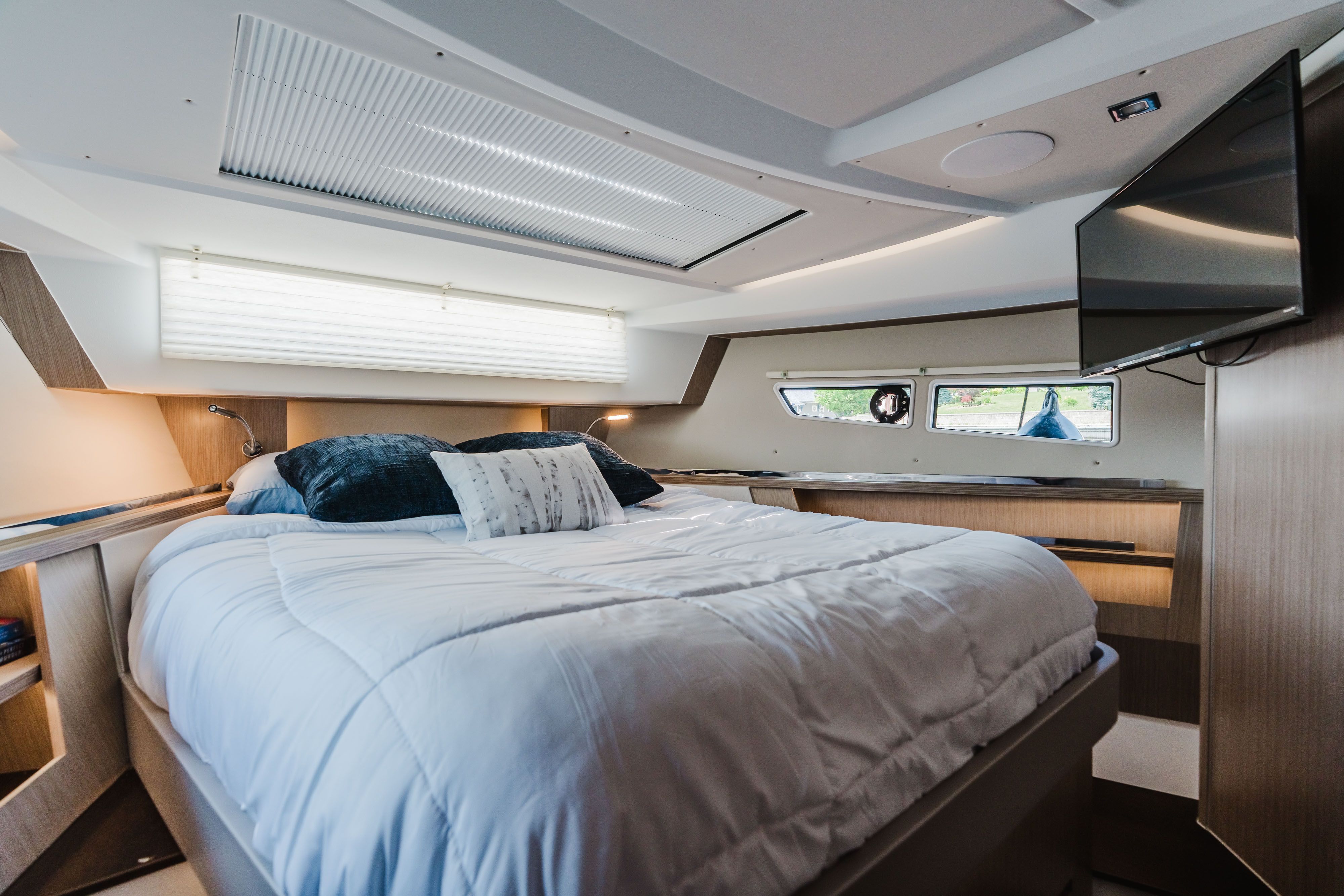 The image shows a cozy cabin with a large bed and windows.