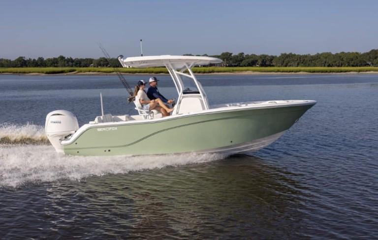 2026 Sea Fox 228 Commander boat cruising on a calm river with two passengers.