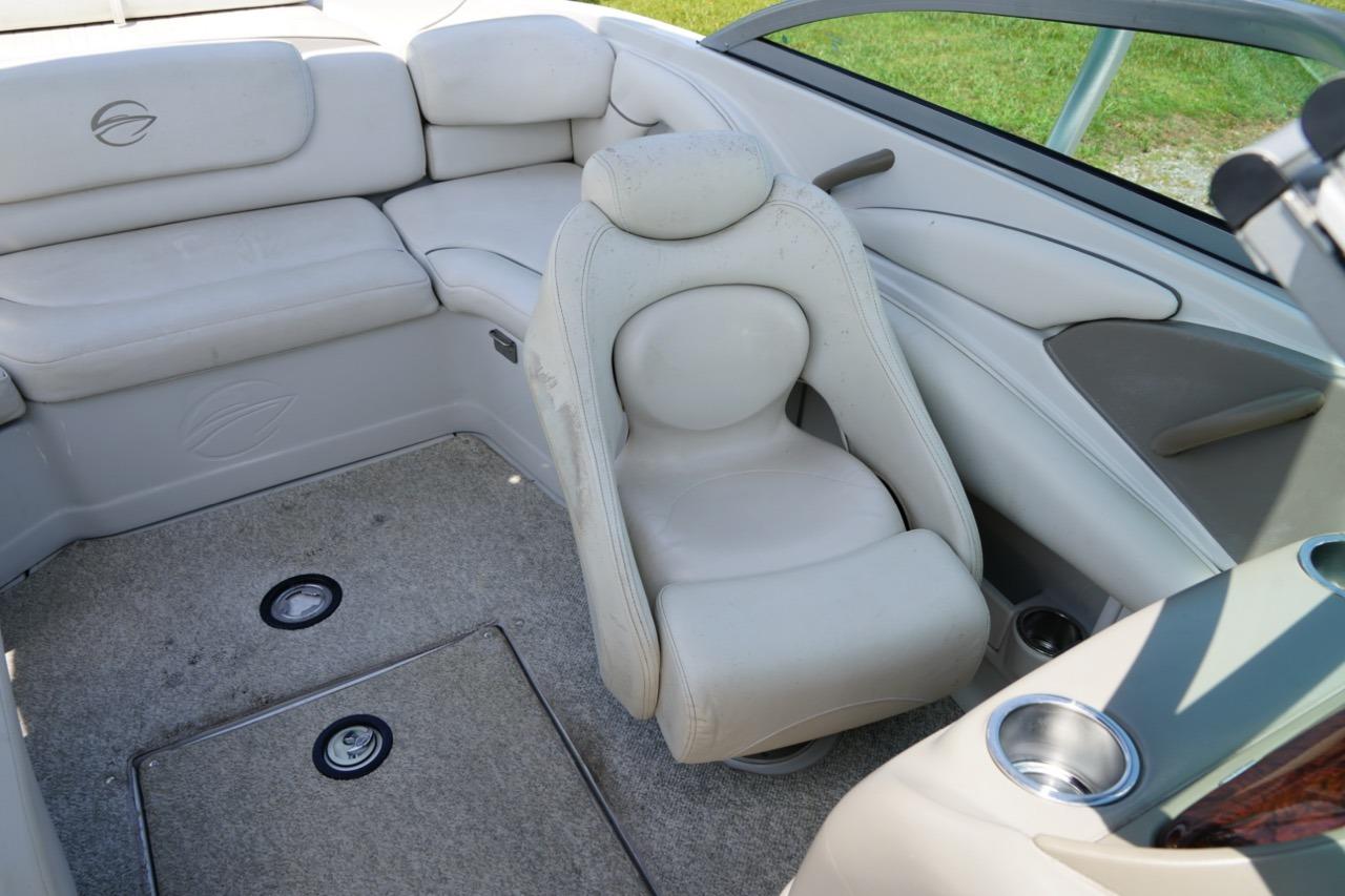 Interior of a 2004 Crownline 216 LS boat, featuring beige seating and carpeted flooring.