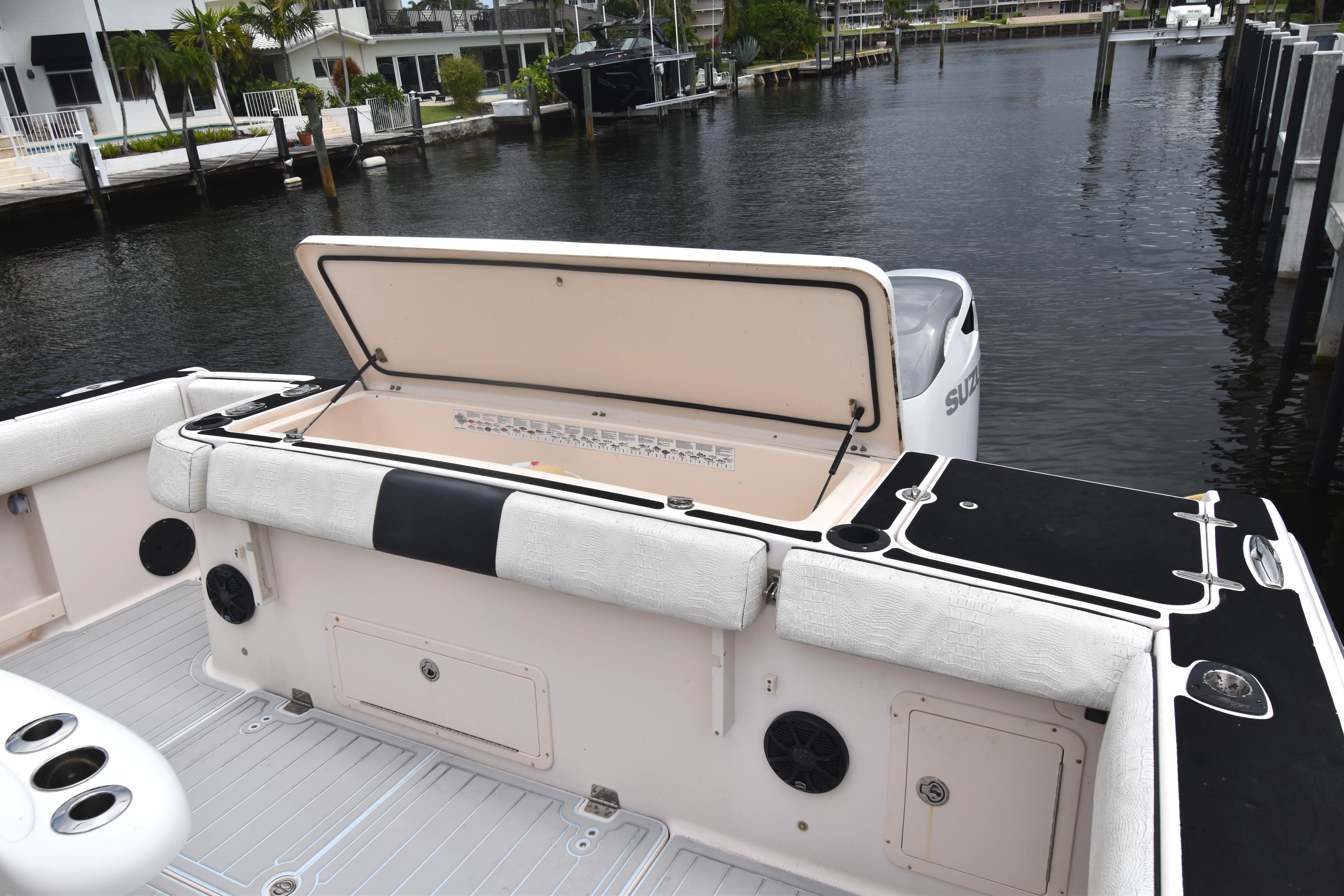 2010 Grady-White Canyon 366 boat with open storage compartment, docked by waterfront homes.