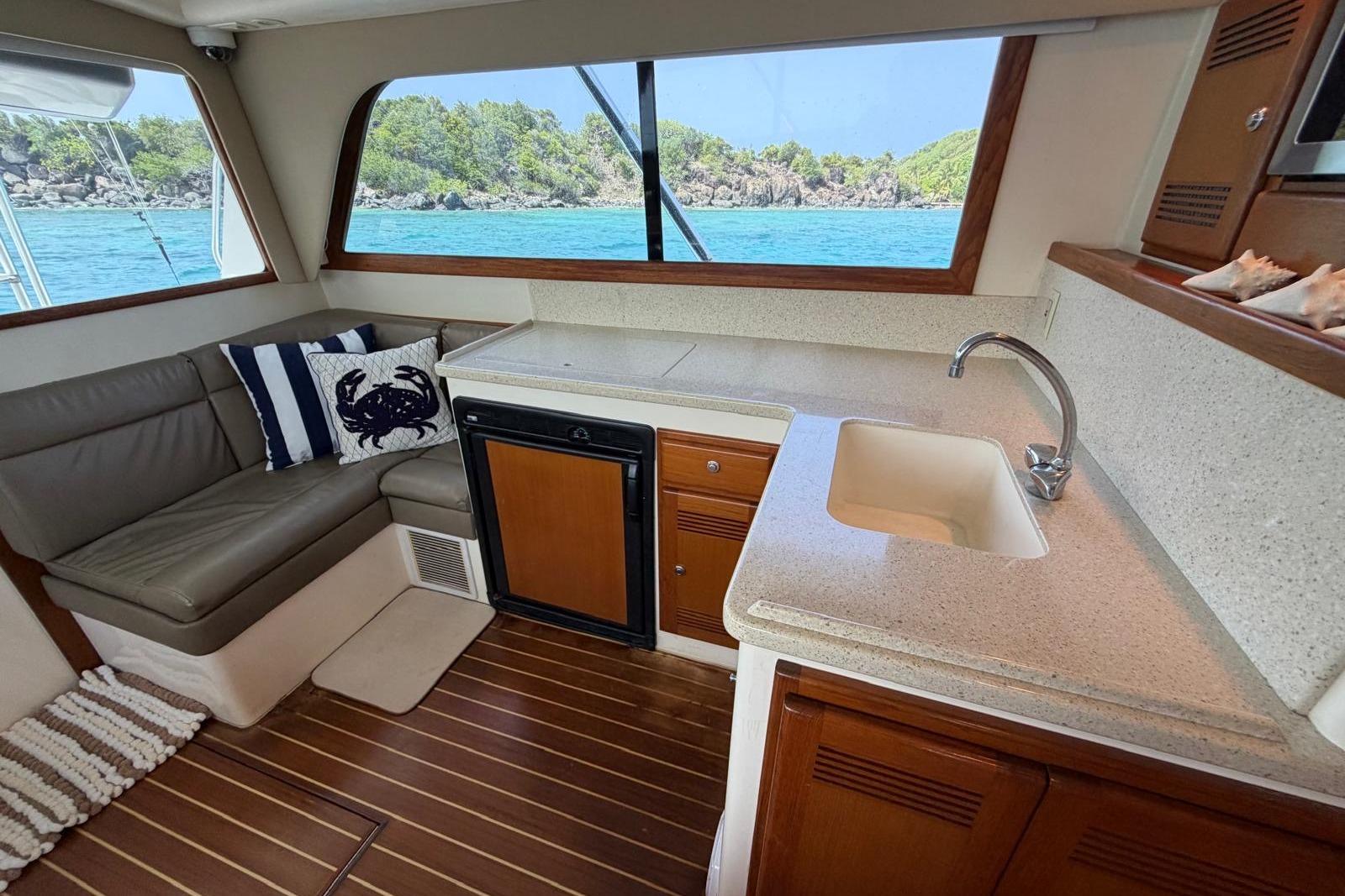 Interior of 2004 Cabo 35 Flybridge yacht with kitchenette and ocean view.